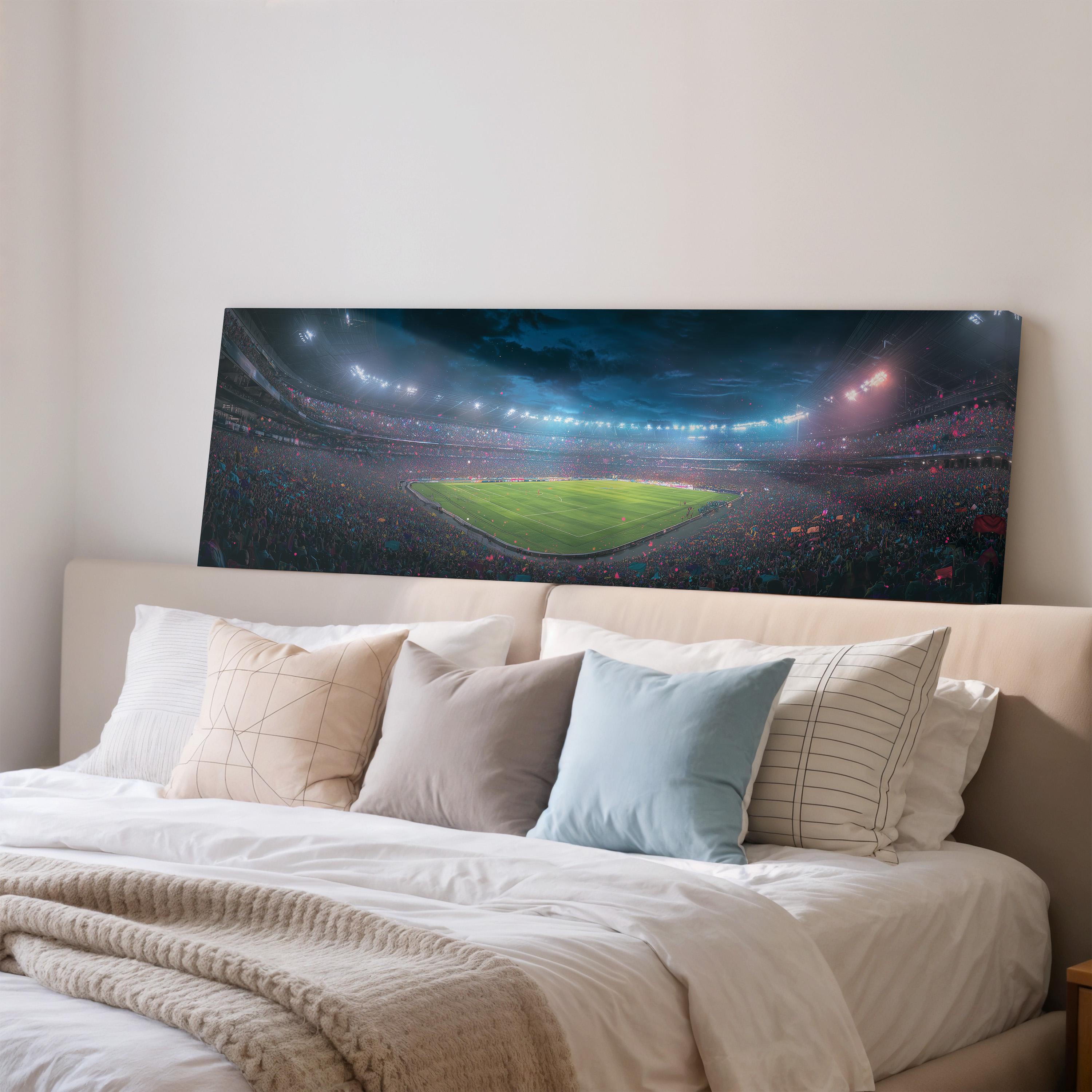 a large, colorful painting of a stadium with a green field and a crowd of people in the stands, displayed on the wall above a bed with pillows.