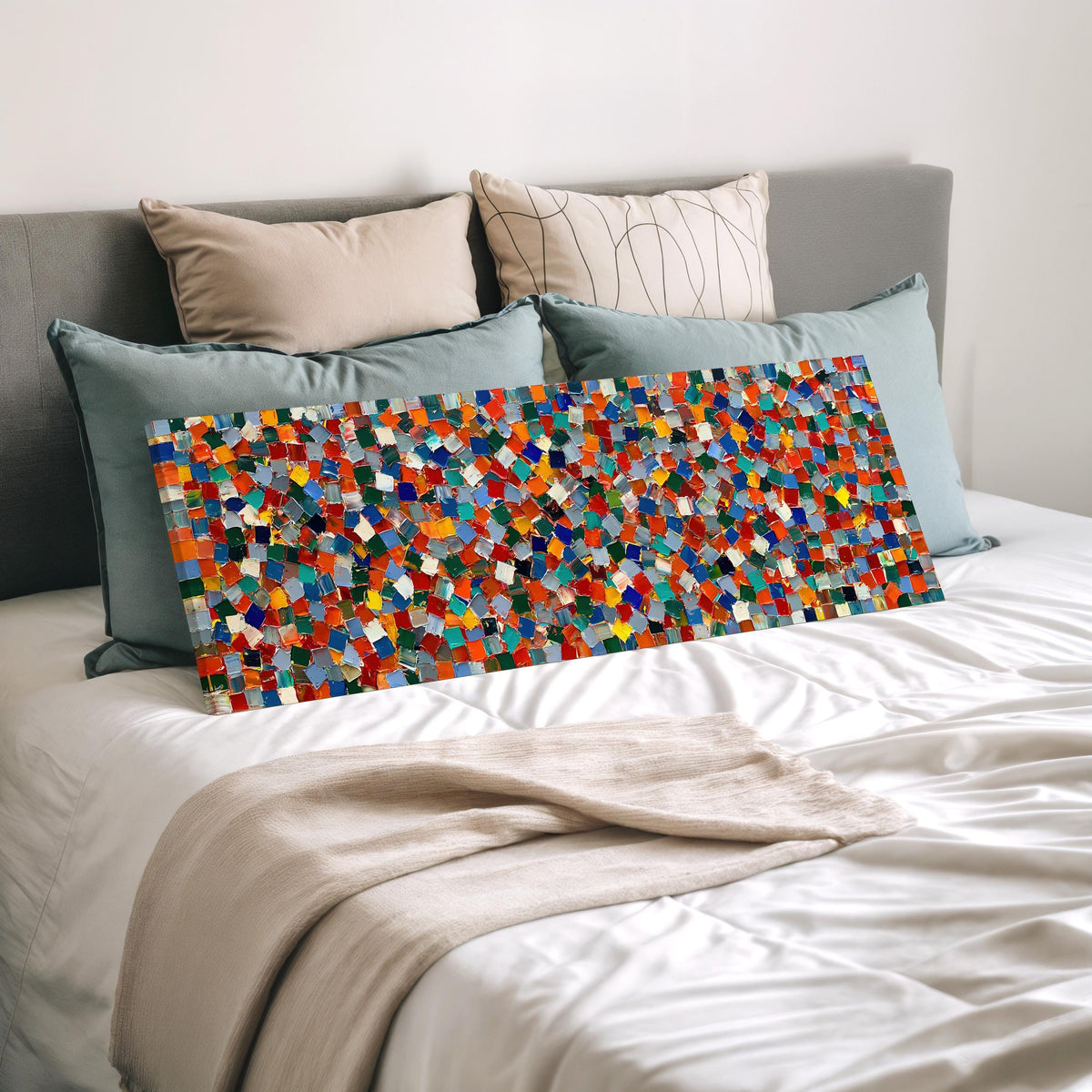 Colorful confetti mosaic squares wide panoramic canvas print laid on a bed to show its size