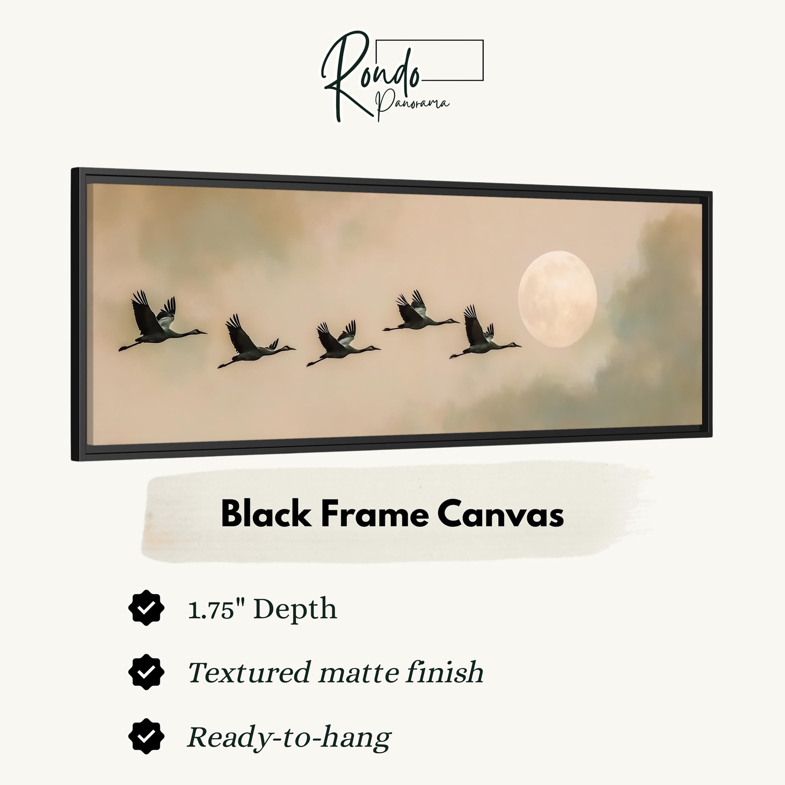 A black frame canvas depicting a flock of birds flying in formation against a backdrop of a full moon and a cloudy sky.