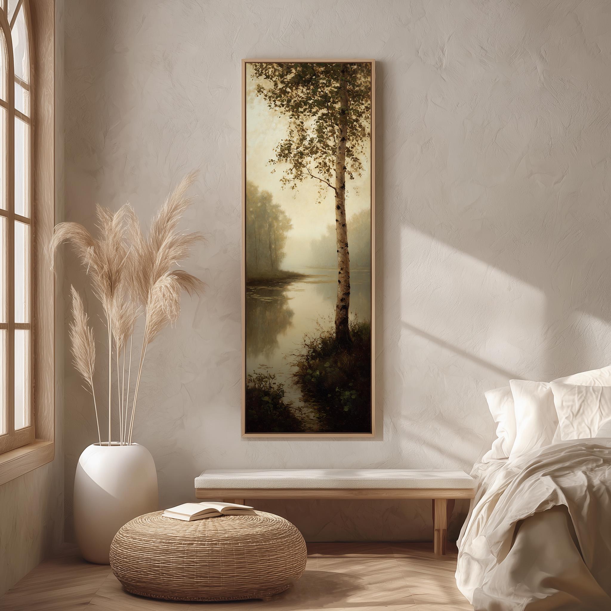 a serene bedroom scene with a large painting of a tree and a lake hanging on the wall, a white bed with a white pillow, a white vase with tall potted plants, and a woven ottoman with a book on it.