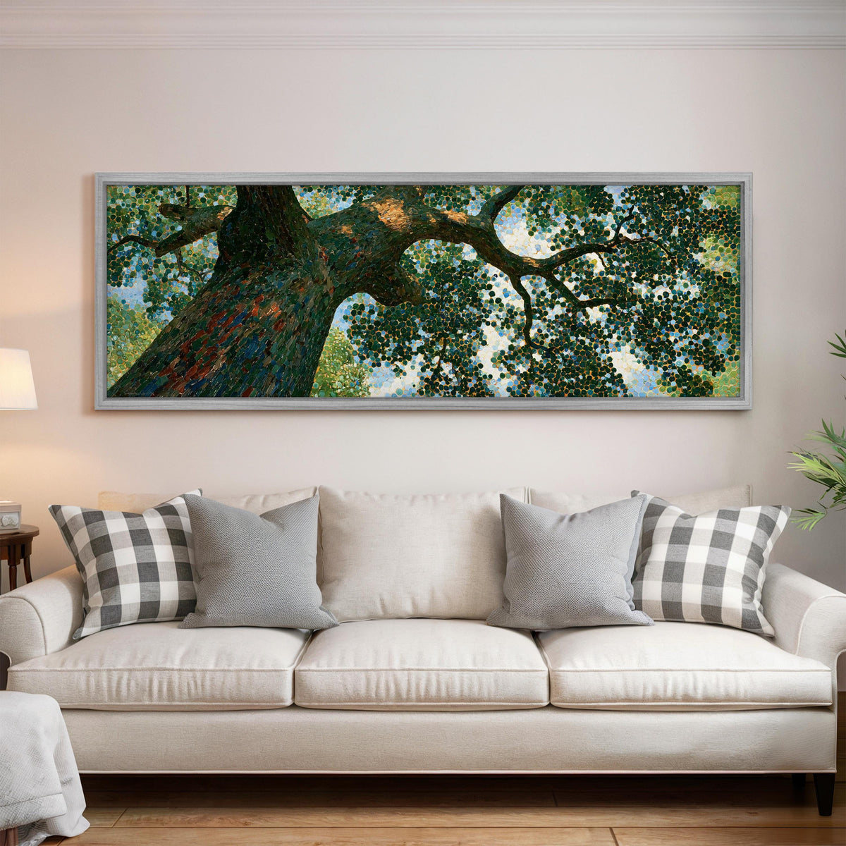 Looking up into an oak canopy panoramic canvas print above a white sofa in a bright living room