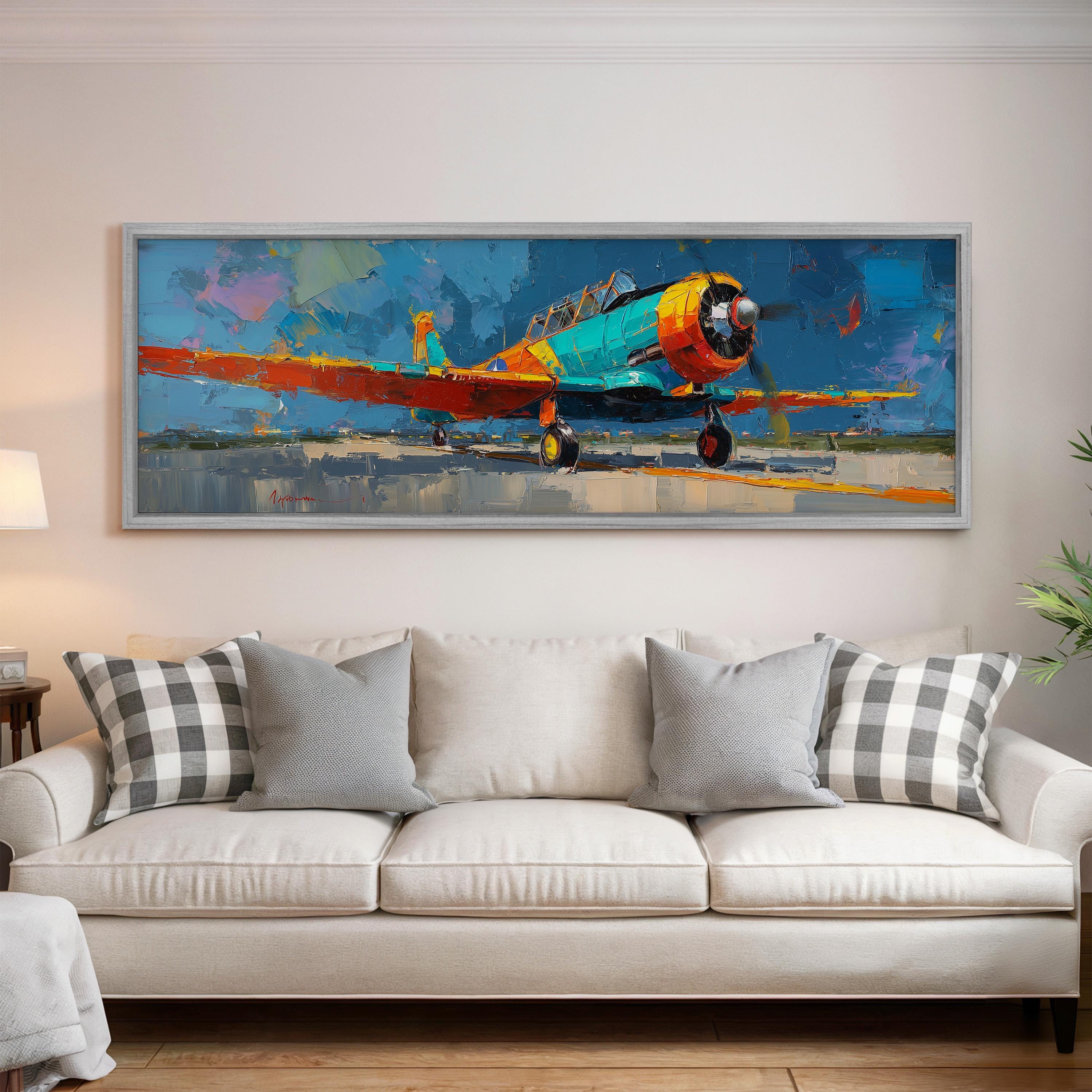 a large, colorful painting of a propeller plane hanging on a wall above a white couch in a living room.