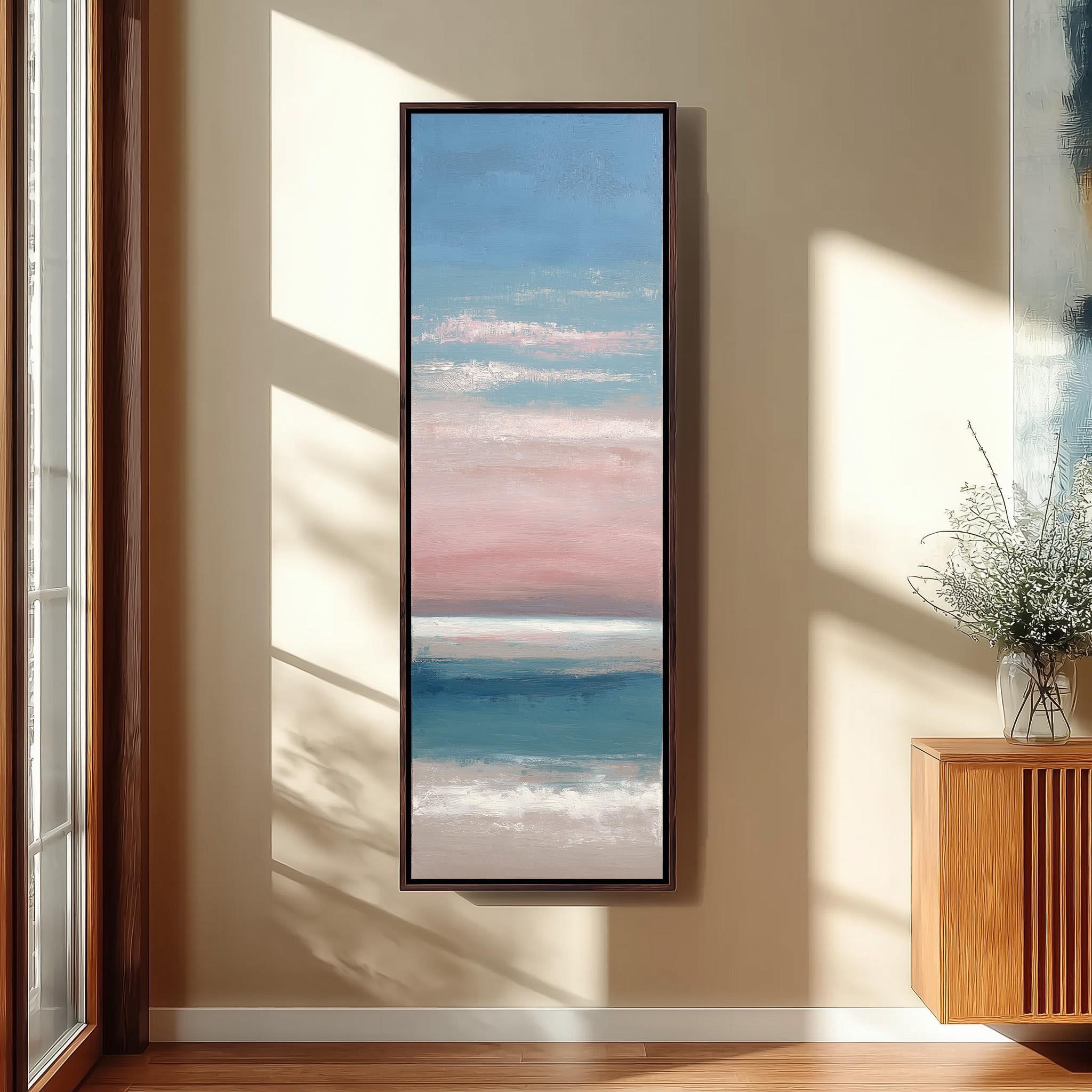a large framed painting hanging on a wall, depicting a serene landscape with a blue sky, pink and white clouds, and a body of water.