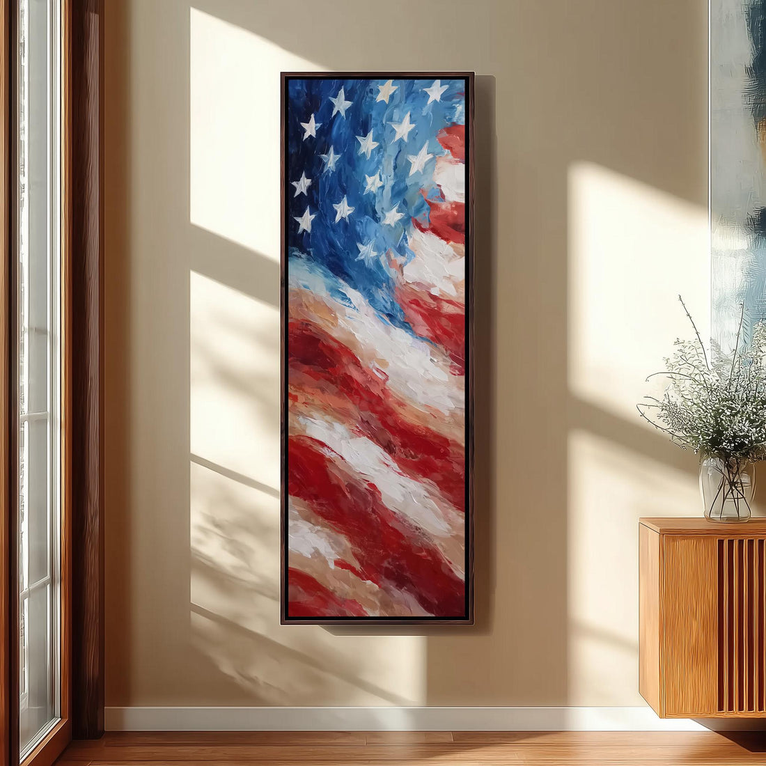 a large framed painting of the American flag hanging on a wall in a room with a wooden cabinet and a vase of flowers.