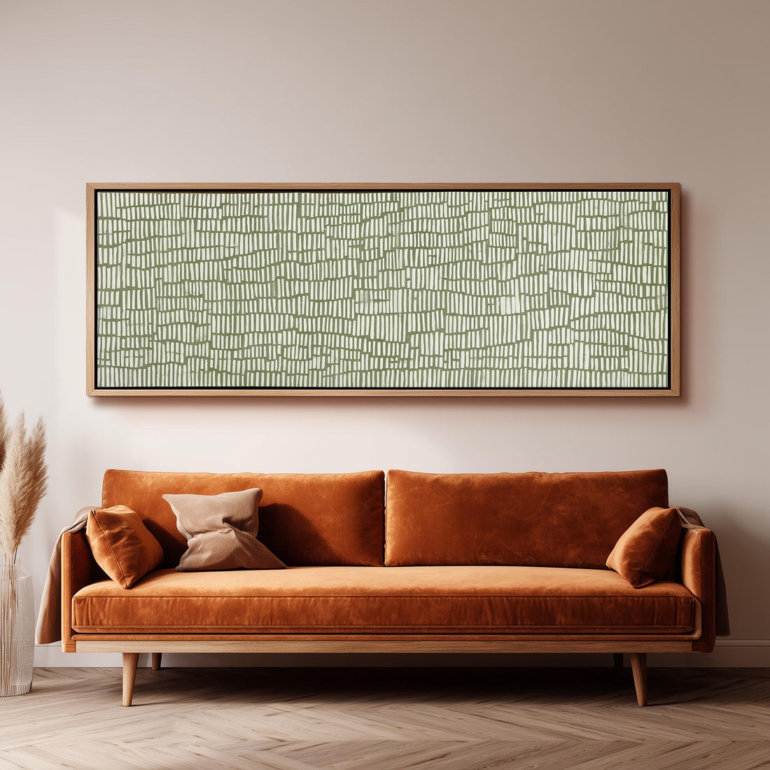 a large, rectangular, abstract painting hanging on a wall above a brown, plush couch with orange cushions.