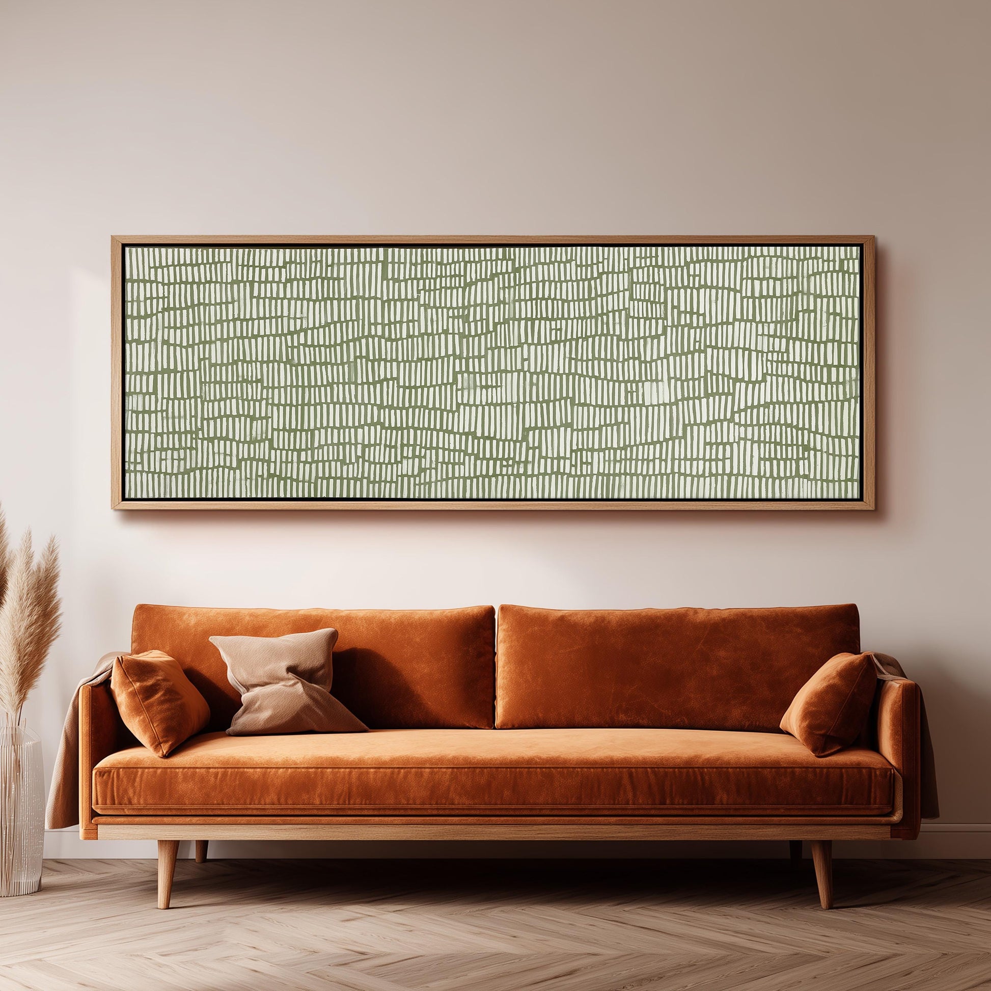 a large, rectangular, abstract painting hanging on a wall above a brown, plush couch with orange cushions.