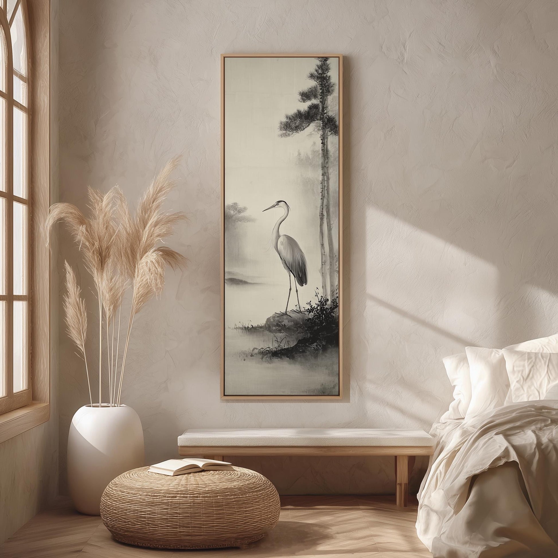 a serene bedroom scene with a large framed painting of a crane standing on a rock, a potted plant, a wooden bench, and a woven ottoman.