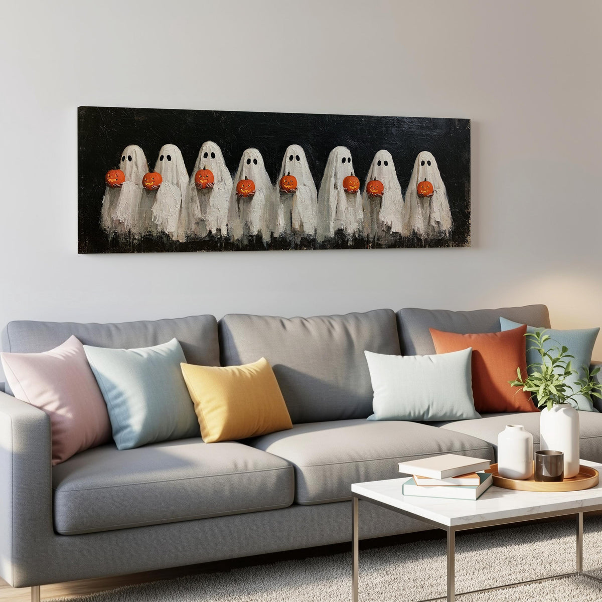 Crowd of huddled ghosts with pumpkins panoramic canvas print above a grey sofa in a living room