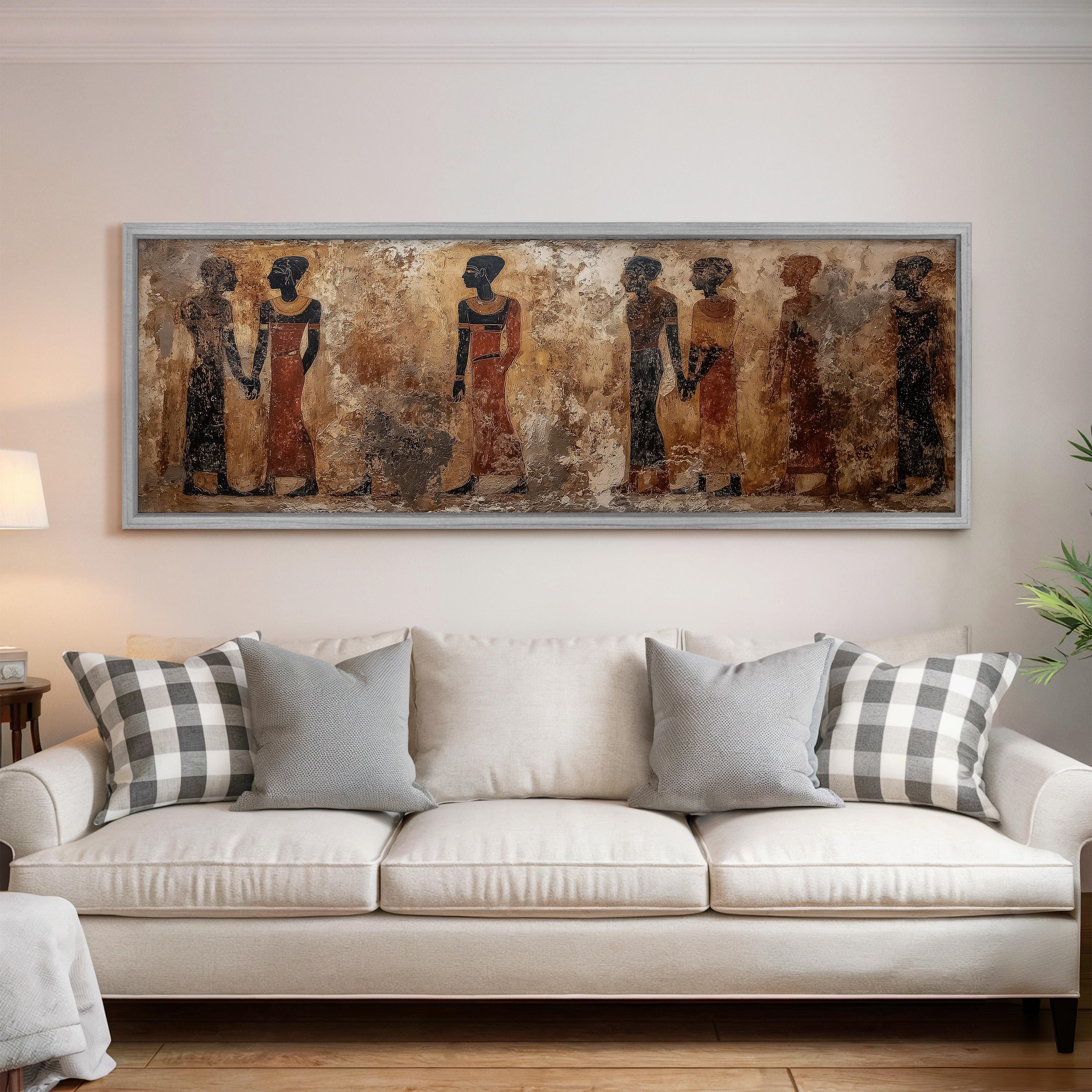 a large, framed painting of ancient Egyptian figures on the wall above a white sofa with gray and white plaid throw pillows.