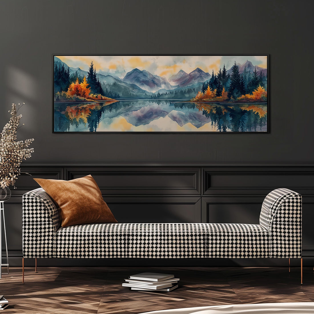 a large, framed painting of a serene landscape with mountains, trees, and a lake, hanging on a wall above a brown sofa.