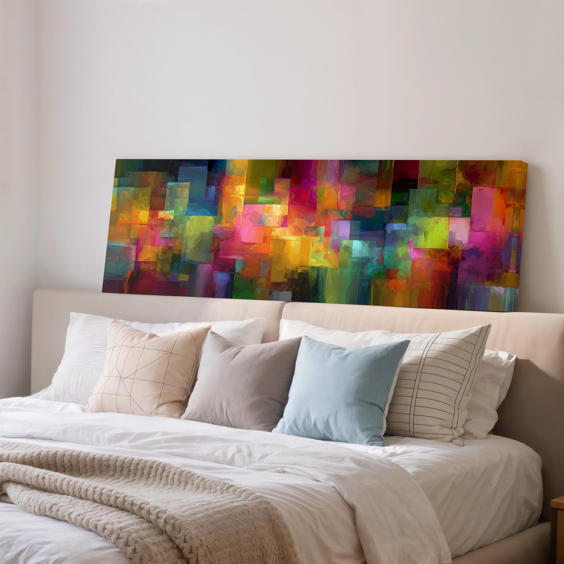 a large, colorful abstract painting hanging on a wall above a bed with white pillows and a gray blanket.