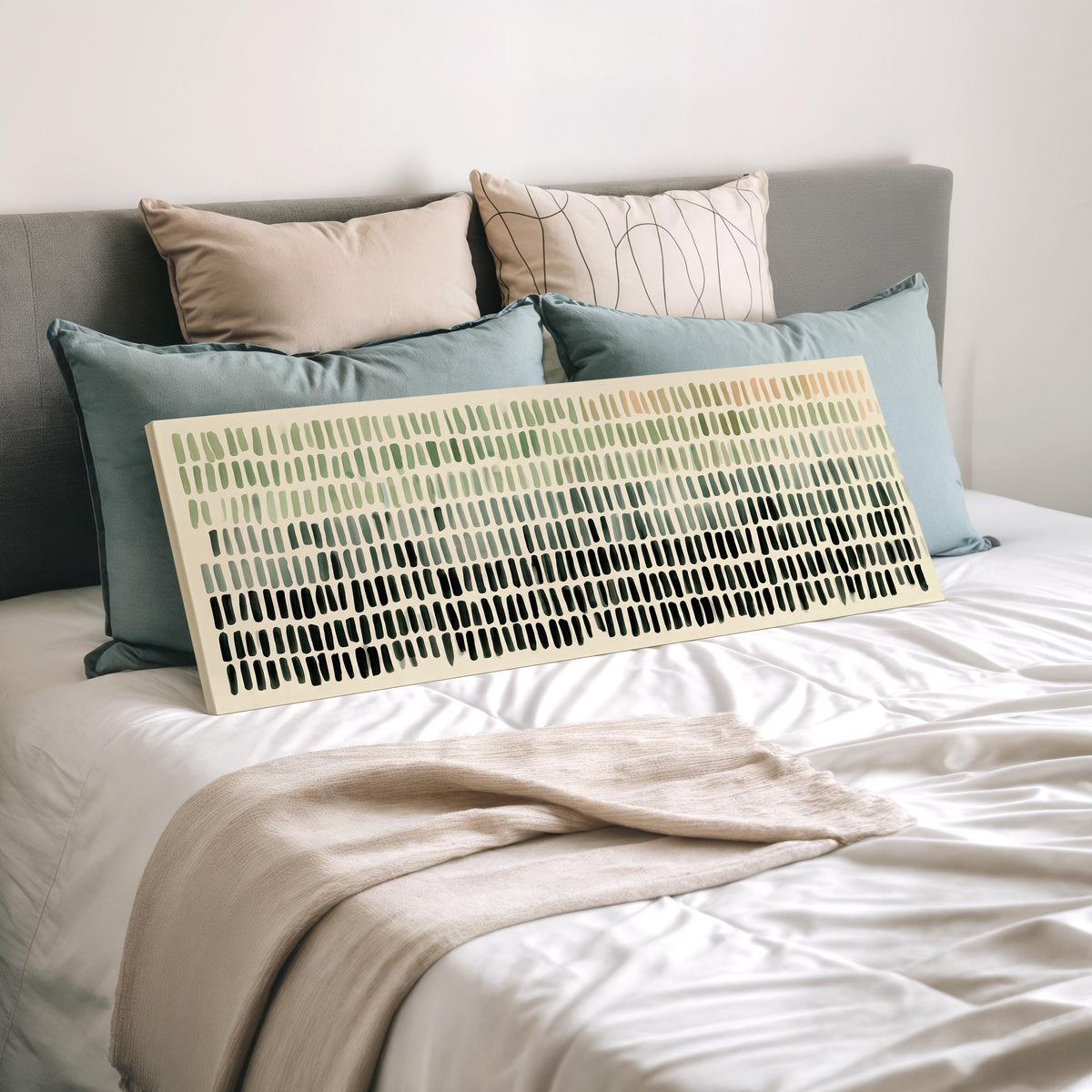 Brushmark dashes fading from sage to charcoal wide panoramic canvas print laid on a bed to show its size