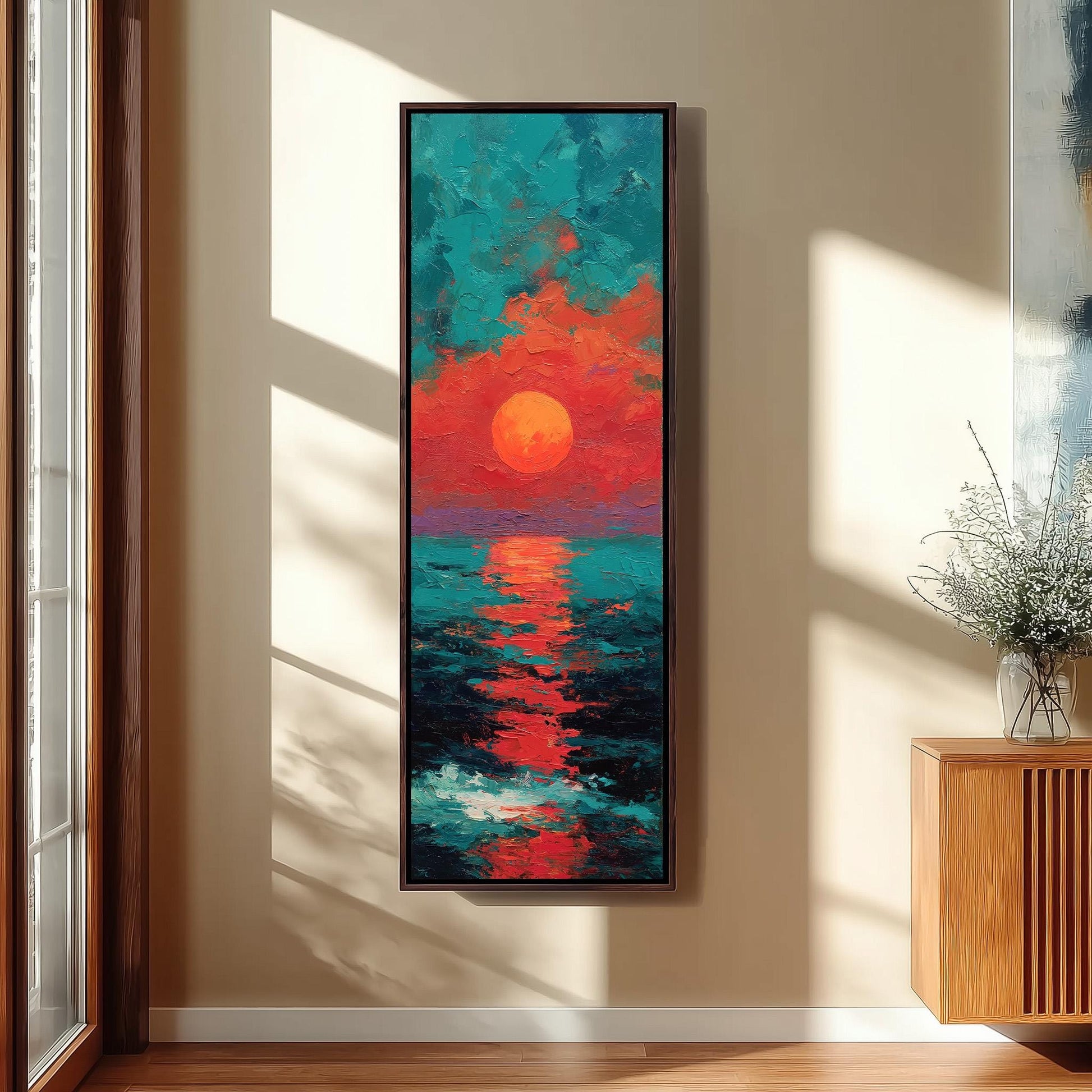a large, colorful painting of a sunset over the ocean, hanging on a wall in a room with a wooden cabinet and a vase of flowers.