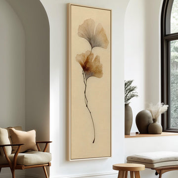 a minimalist living room with a large framed artwork of a plant on the wall, a wooden chair, a small table, and a window with a plant on the sill.
