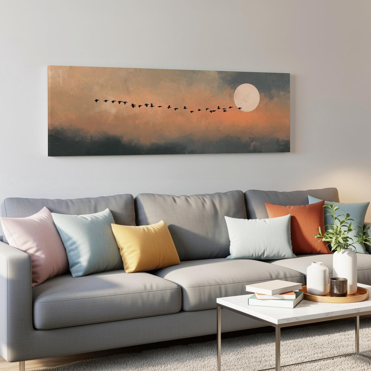 Geese flying toward the moon at twilight panoramic canvas print above a grey sofa in a living room
