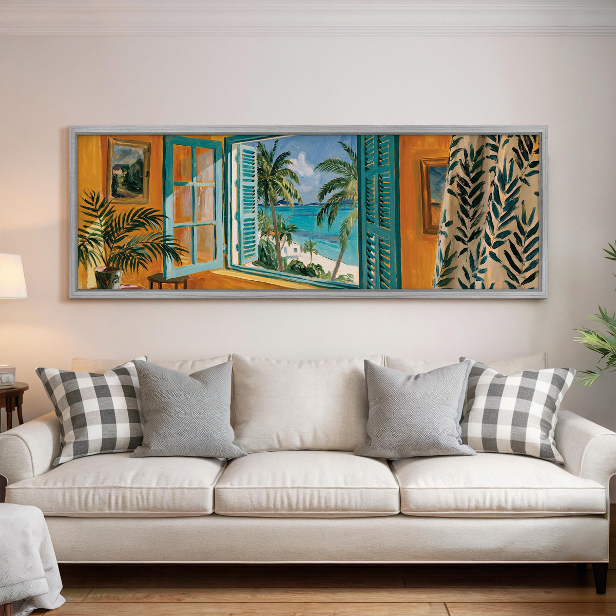 Beach house window overlooking palms and sea panoramic canvas print above a white sofa in a bright living room