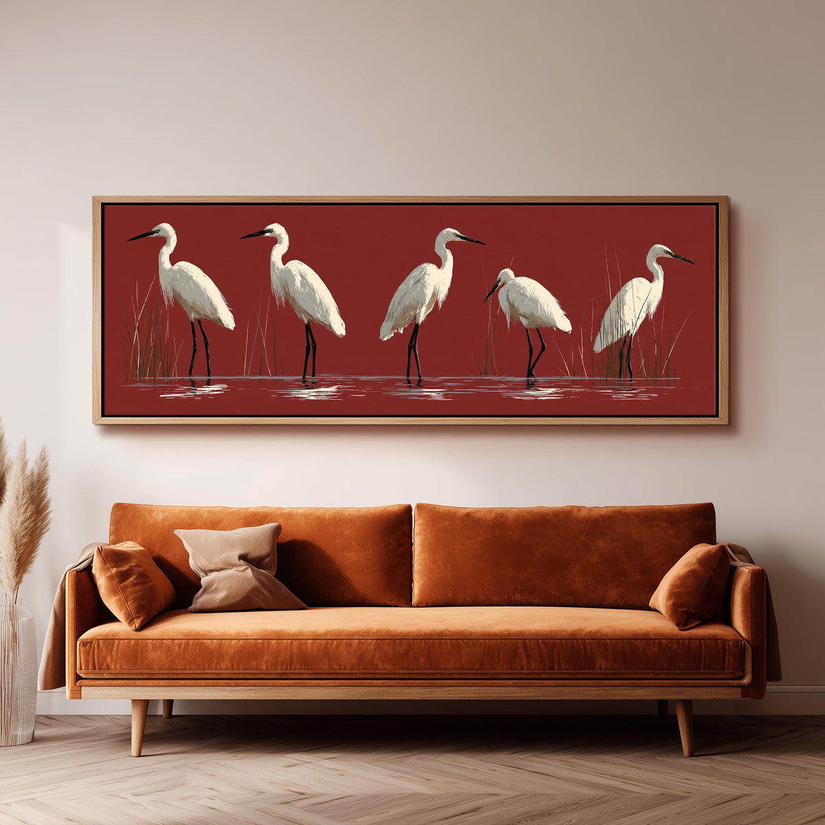 White egrets wading on crimson red long horizontal canvas print above a sofa in a living room