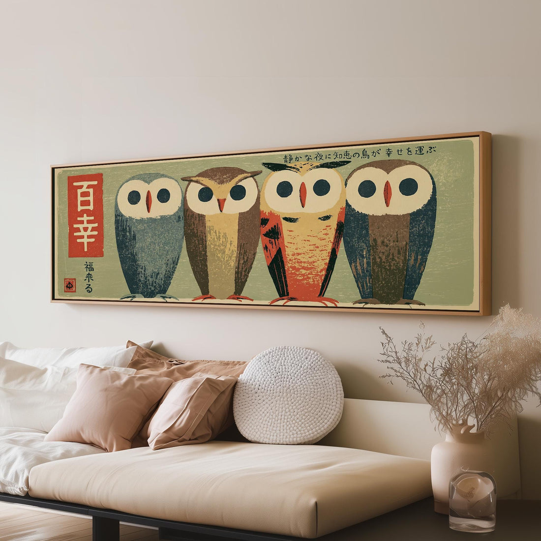 Four owls in a Japanese woodblock style long horizontal canvas print above a sofa in a living room