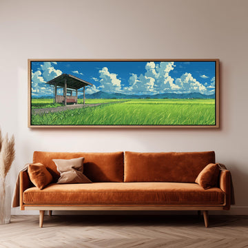 a large, framed painting of a serene landscape with a grassy field, a wooden structure, and a blue sky with white clouds. The painting is hung on a wall above a brown sofa with a wooden frame.
