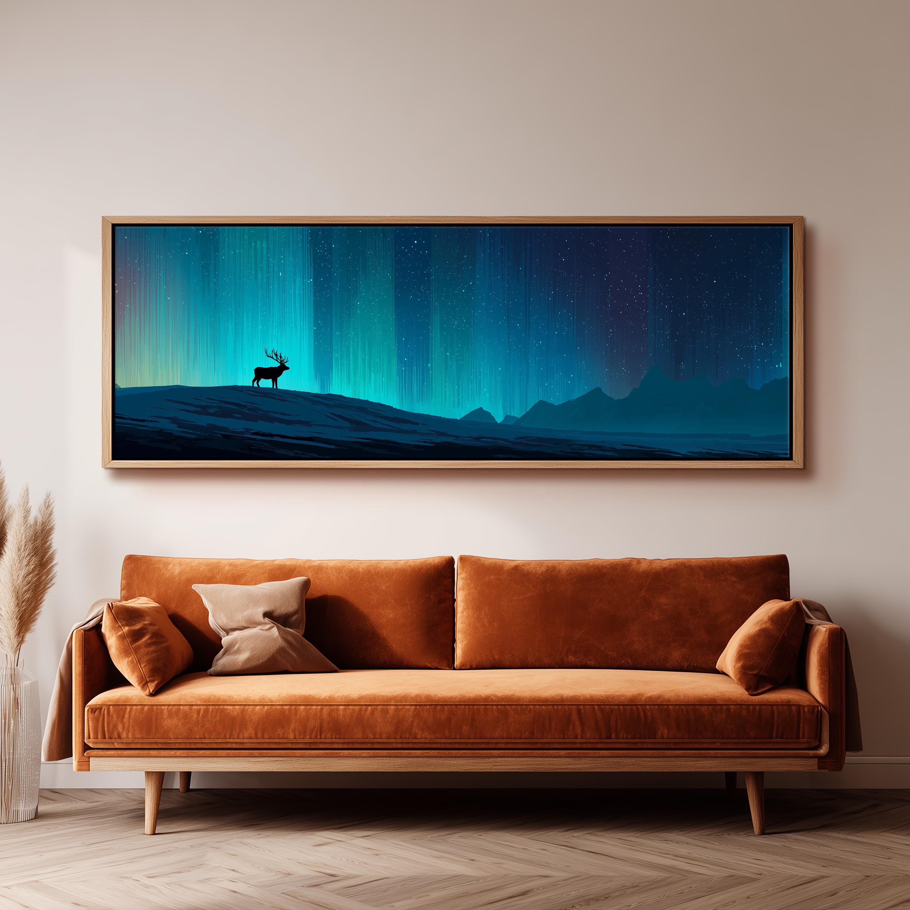 a large, framed painting of a deer standing on a hill against a night sky with a stunning display of the northern lights.