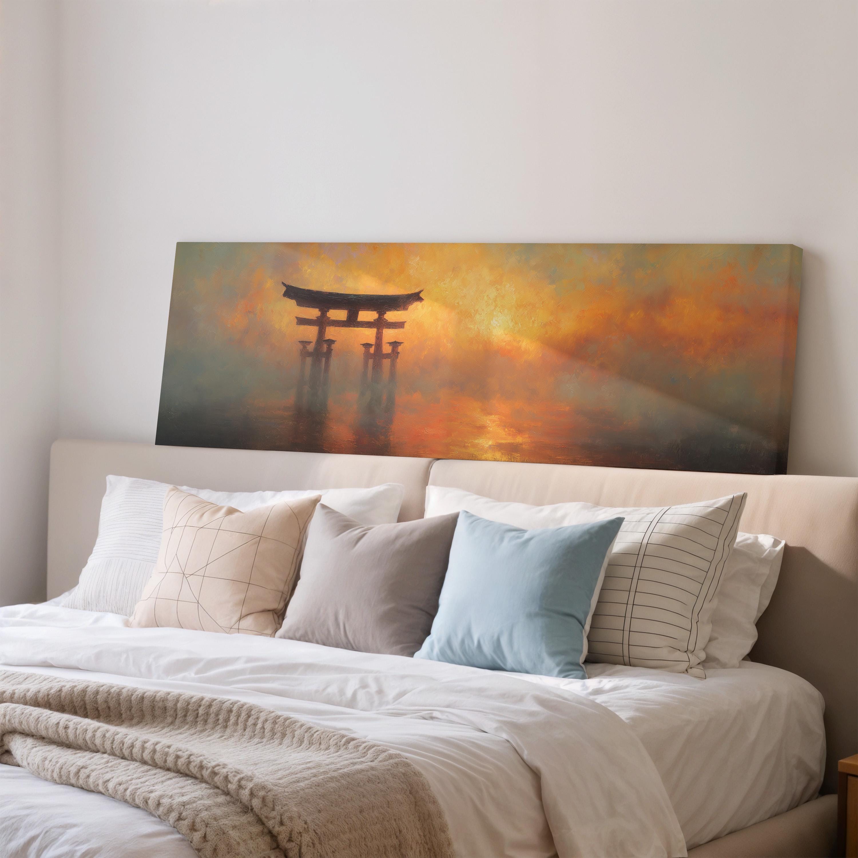 a large painting of a torii gate on a wall above a bed with white pillows and a gray blanket.
