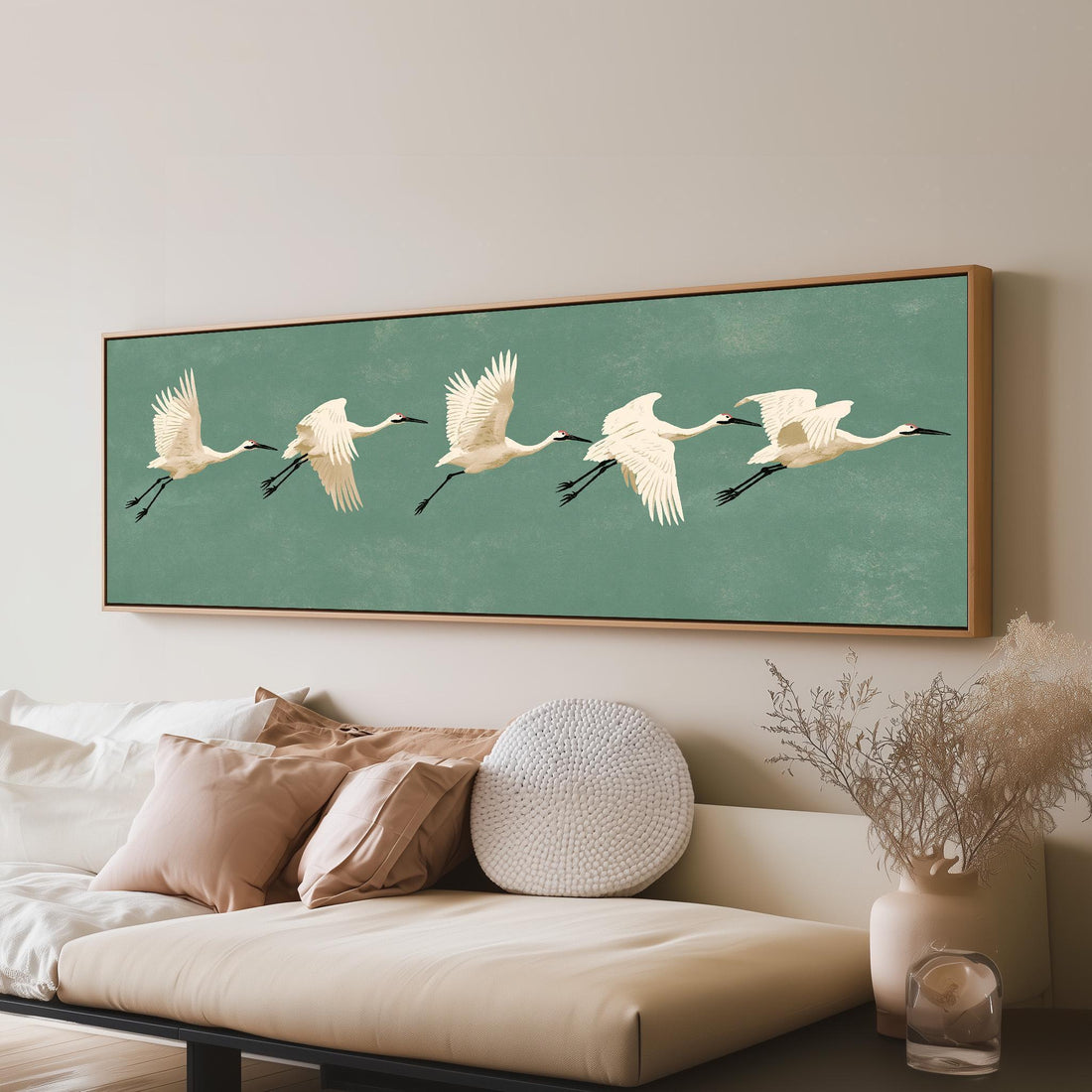 White cranes taking flight long horizontal canvas print above a sofa in a living room