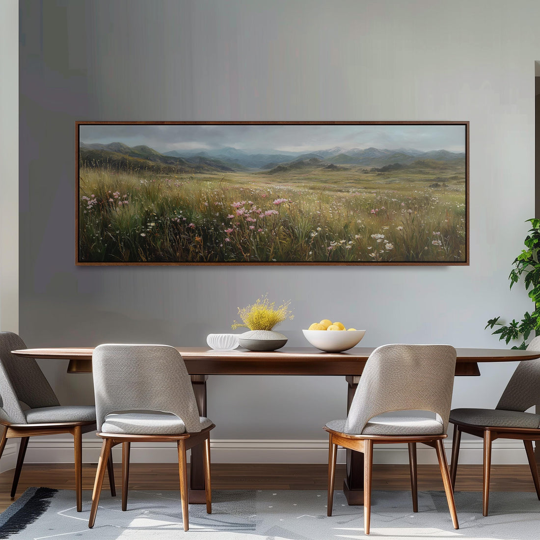 a large, framed painting of a field with flowers hanging on a wall above a brown sofa.