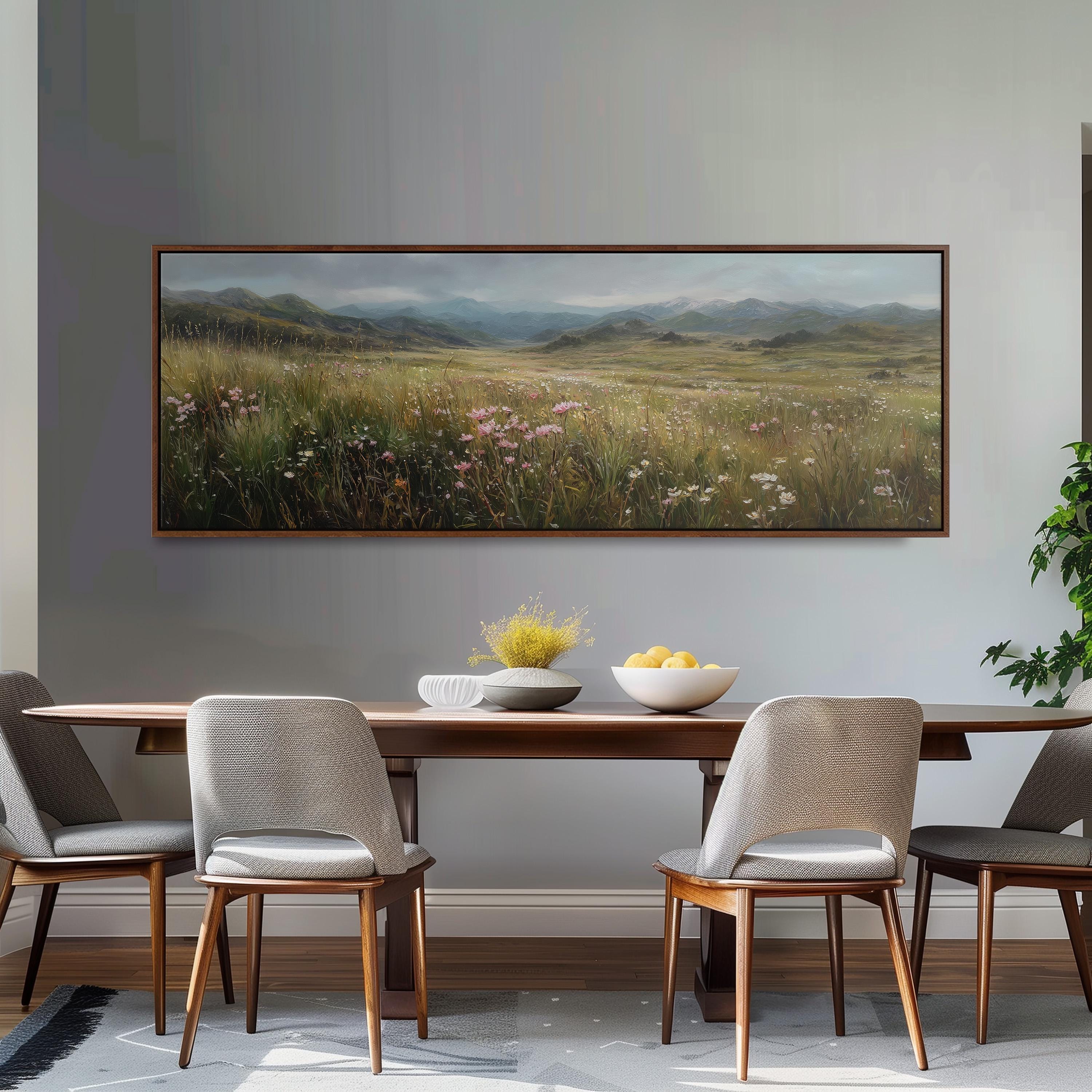 a dining room with a large painting of a field of flowers hanging on the wall above a wooden dining table with four chairs. The table is set with a bowl of fruit and a vase of flowers, creating a cozy and inviting atmosphere.