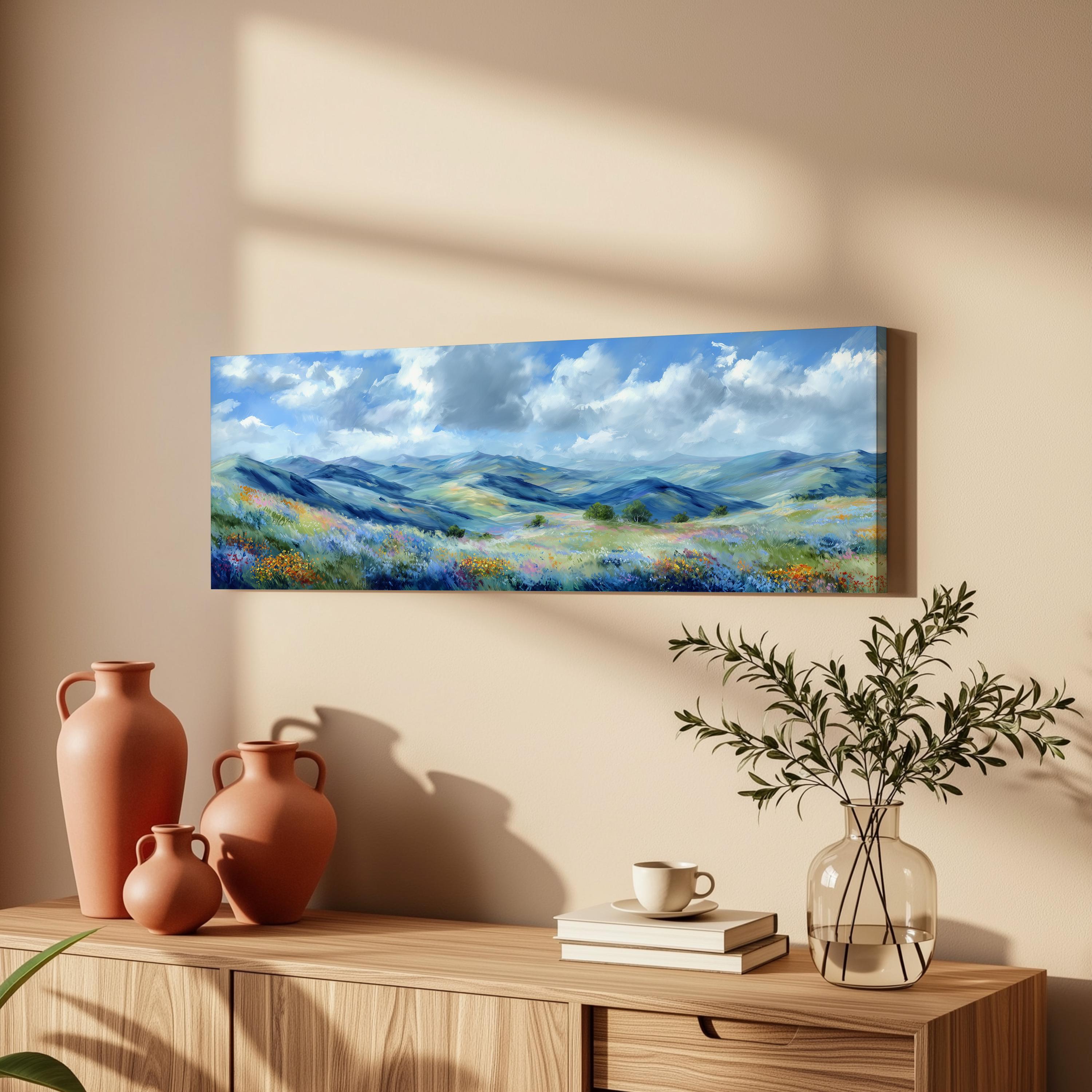 a wooden cabinet with a painting of a mountain landscape hanging on the wall above it. The cabinet also has three orange vases and a glass vase with greenery on top.