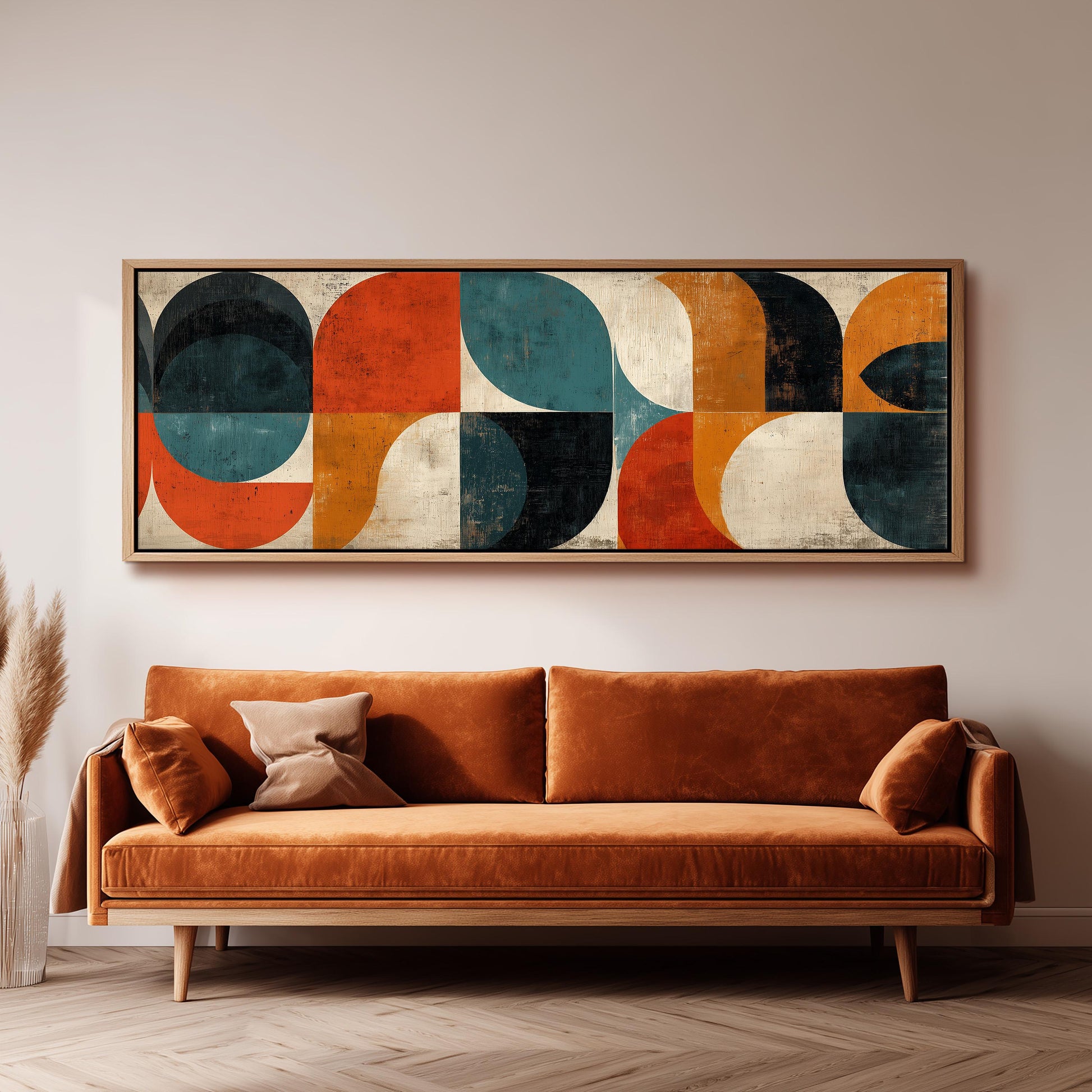 a large abstract painting hanging on a wall above a brown sofa in a living room setting.