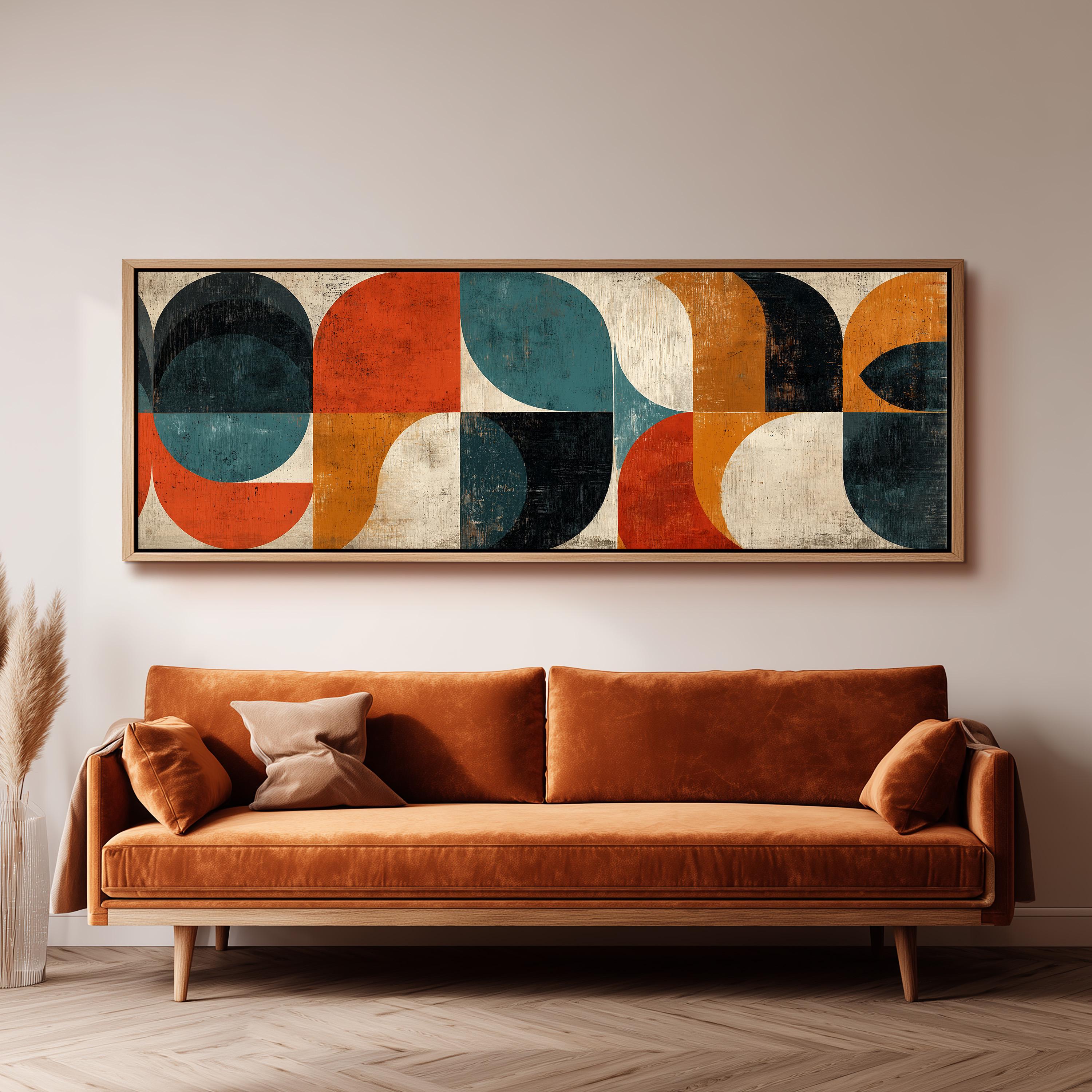 a large abstract painting hanging on a wall above a brown sofa in a living room setting.