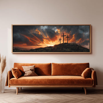 a large, framed painting of a dramatic landscape with three crosses silhouetted against a sky filled with clouds and a sunset.