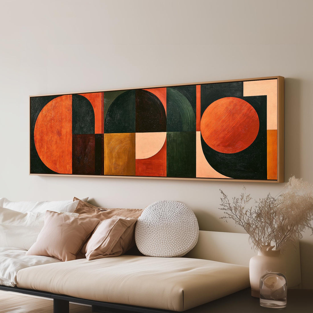 Orange circles and arches on forest green long horizontal canvas print above a sofa in a living room