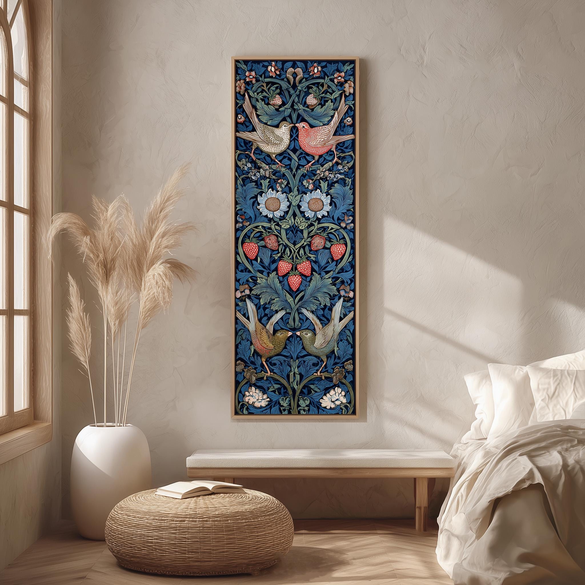a large, colorful tapestry hanging on a wall in a bedroom. The tapestry is adorned with intricate floral and bird designs in shades of blue, red, and green. The room has a minimalist and modern aesthetic, with a white bed, a wooden bench, and a woven ottoman. The overall color scheme of the room is predominantly white and beige, with pops of color from the tapestry and the potted plant.