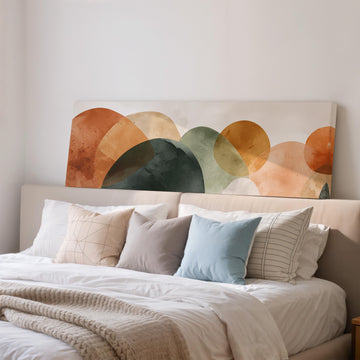 a large bed with a white comforter and various pillows, including a blue pillow and a striped pillow. Above the bed, there is a large abstract painting or artwork with a colorful design of circles and shapes.