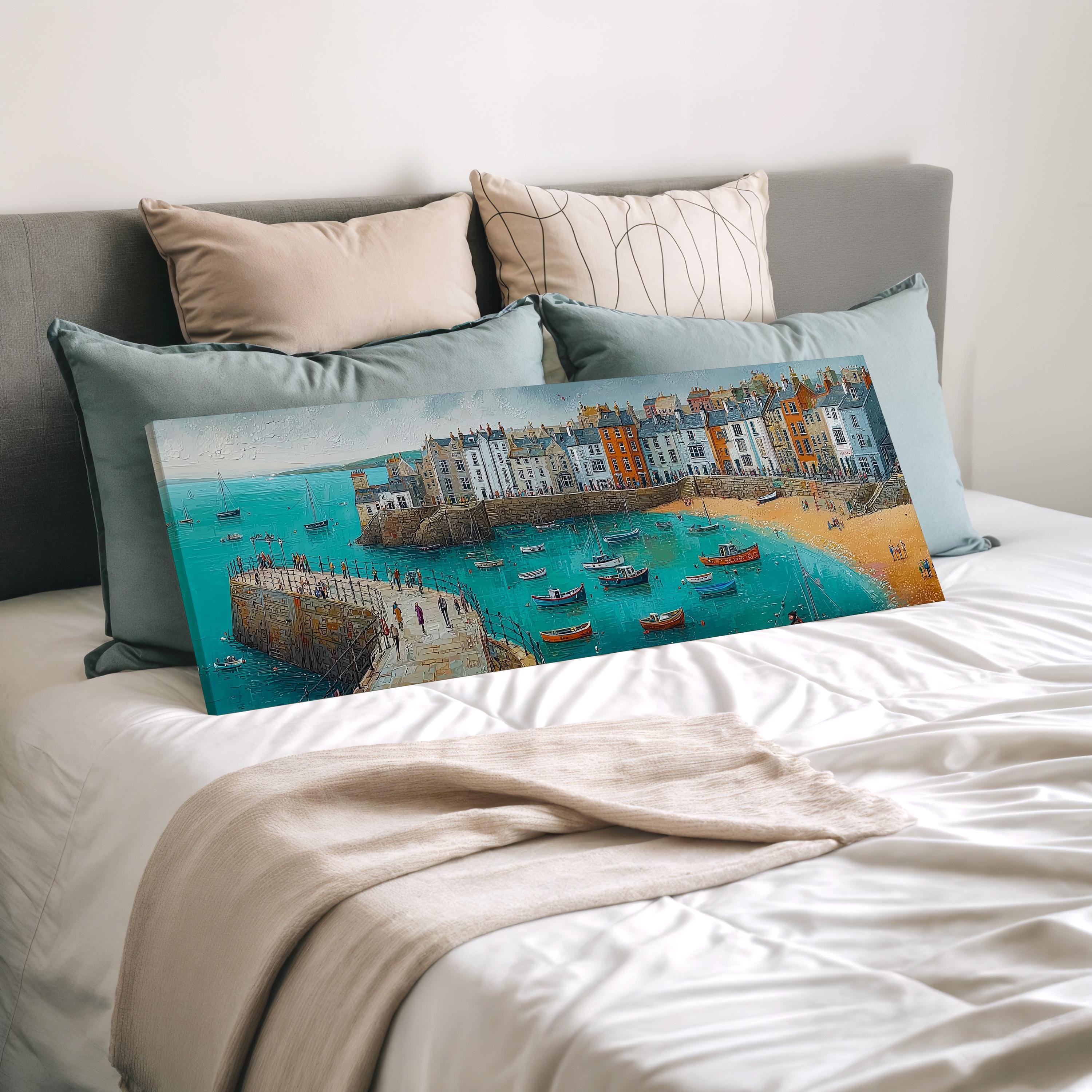 a large painting of a coastal town with boats on the water, displayed on a bed with a white comforter and pillows.