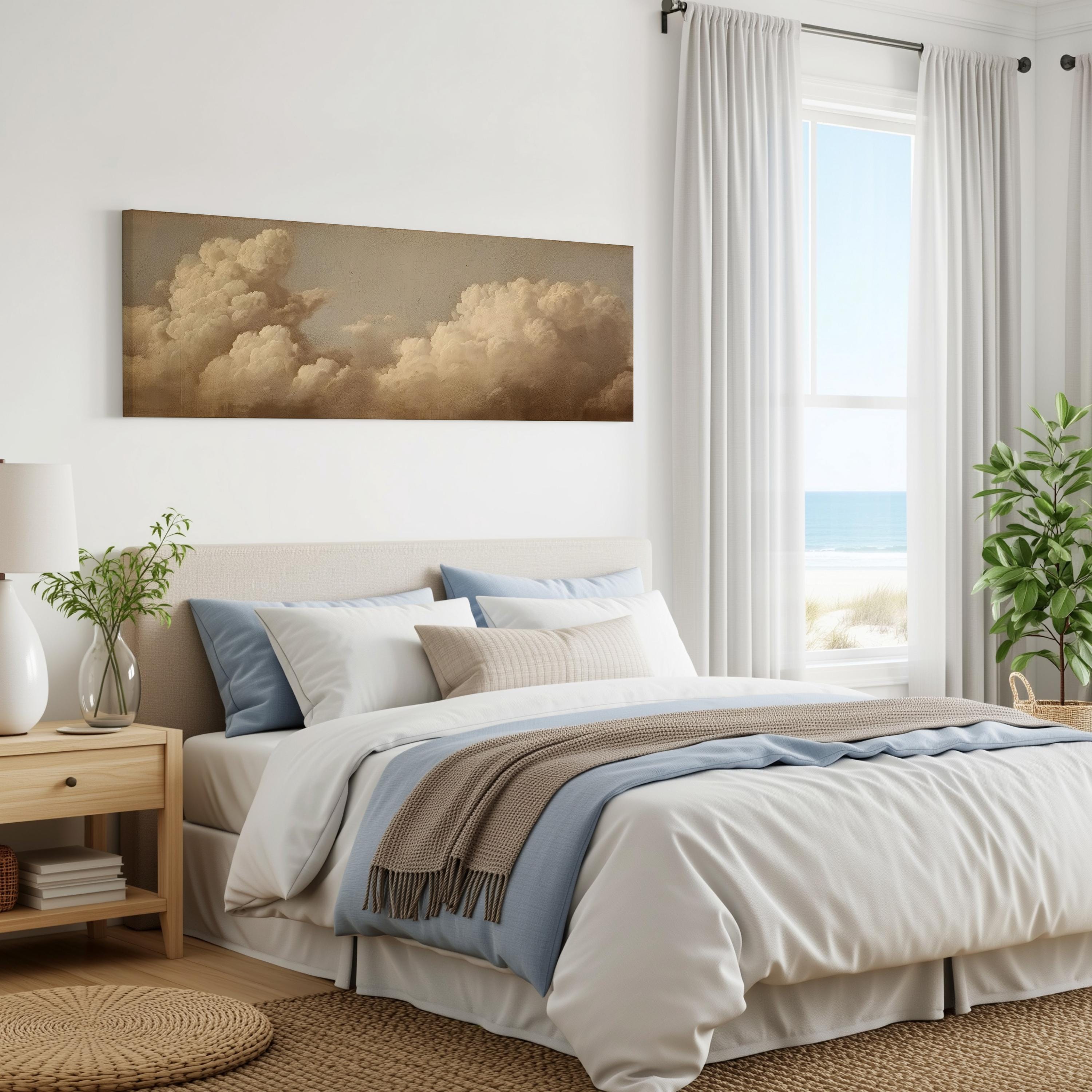 a serene bedroom with a large bed, a nightstand, and a painting of clouds on the wall. The room has a neutral color scheme with white walls, a beige bedspread, and a blue throw blanket. The window offers a view of the ocean, creating a peaceful and relaxing atmosphere.