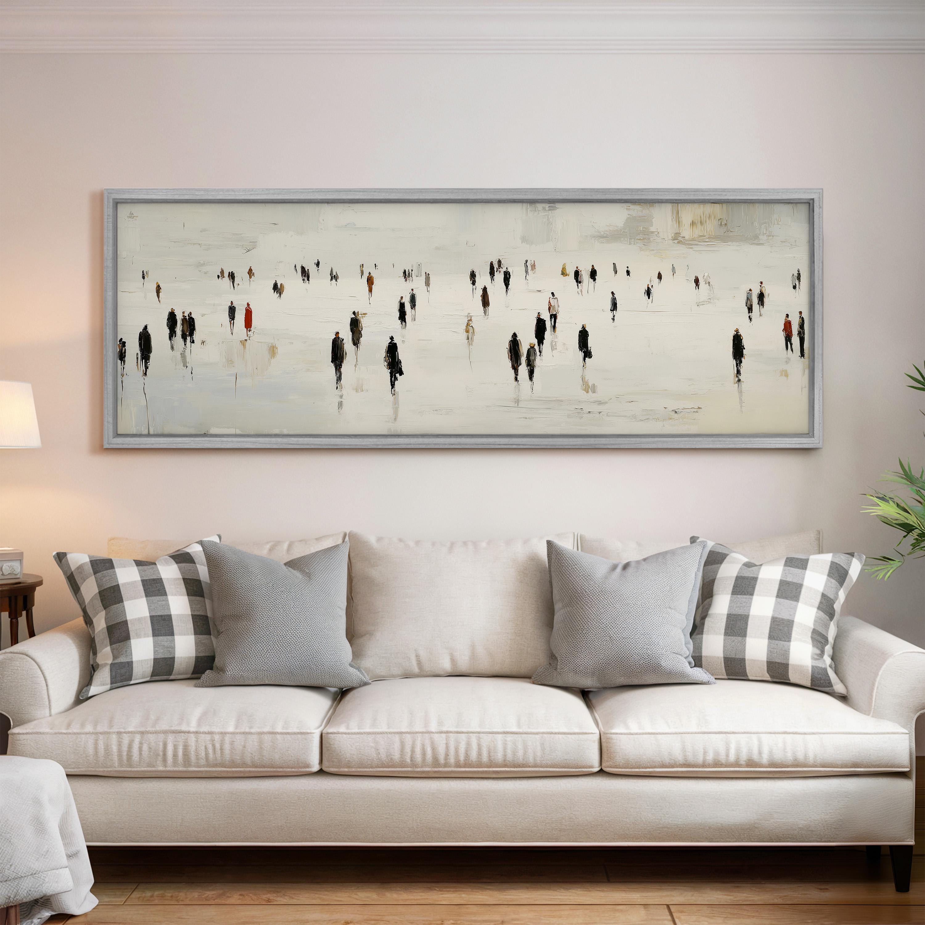 a large painting of people walking on a snowy street, hanging on a wall above a white couch with gray and white patterned pillows.