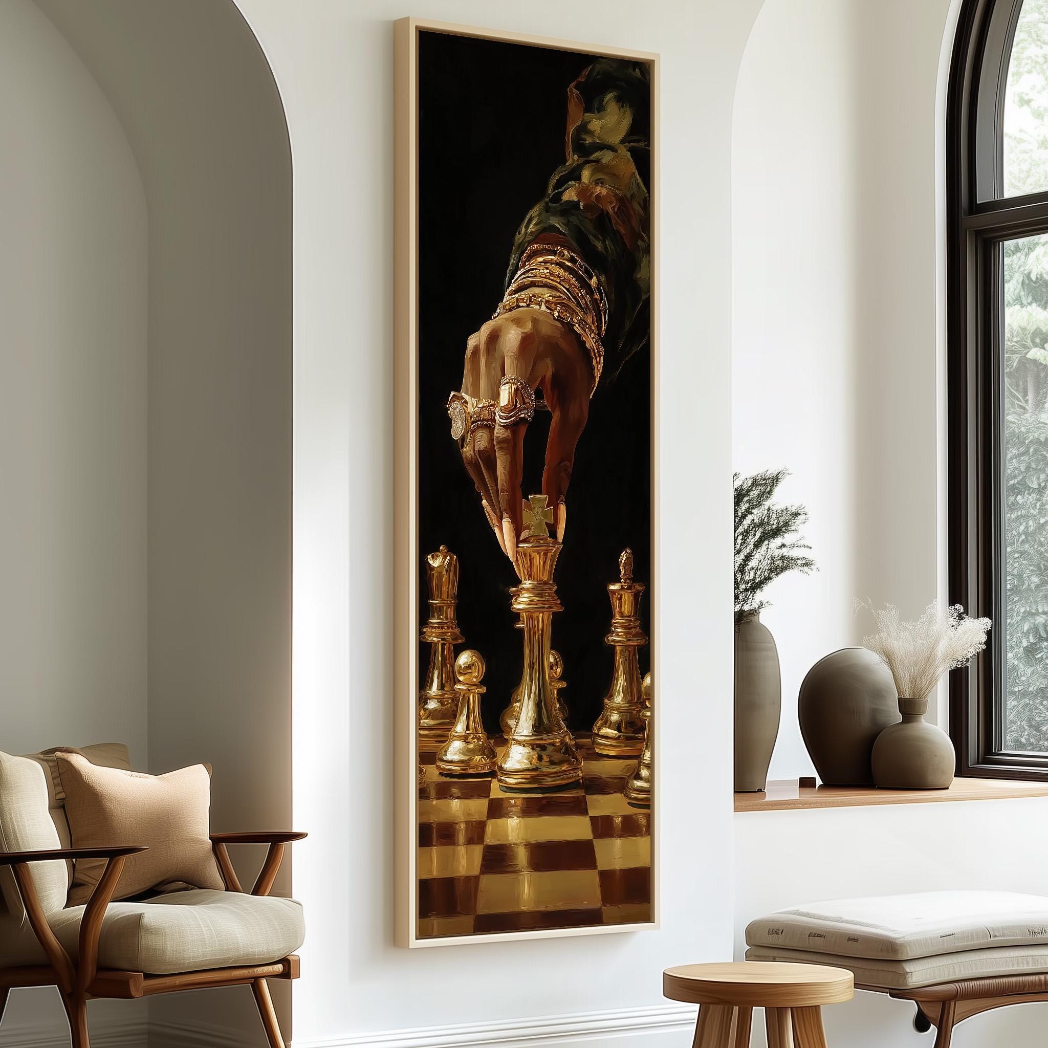 a large painting of a hand holding a chess piece, with a chessboard in the background, hanging on a wall in a room with a window and a chair.