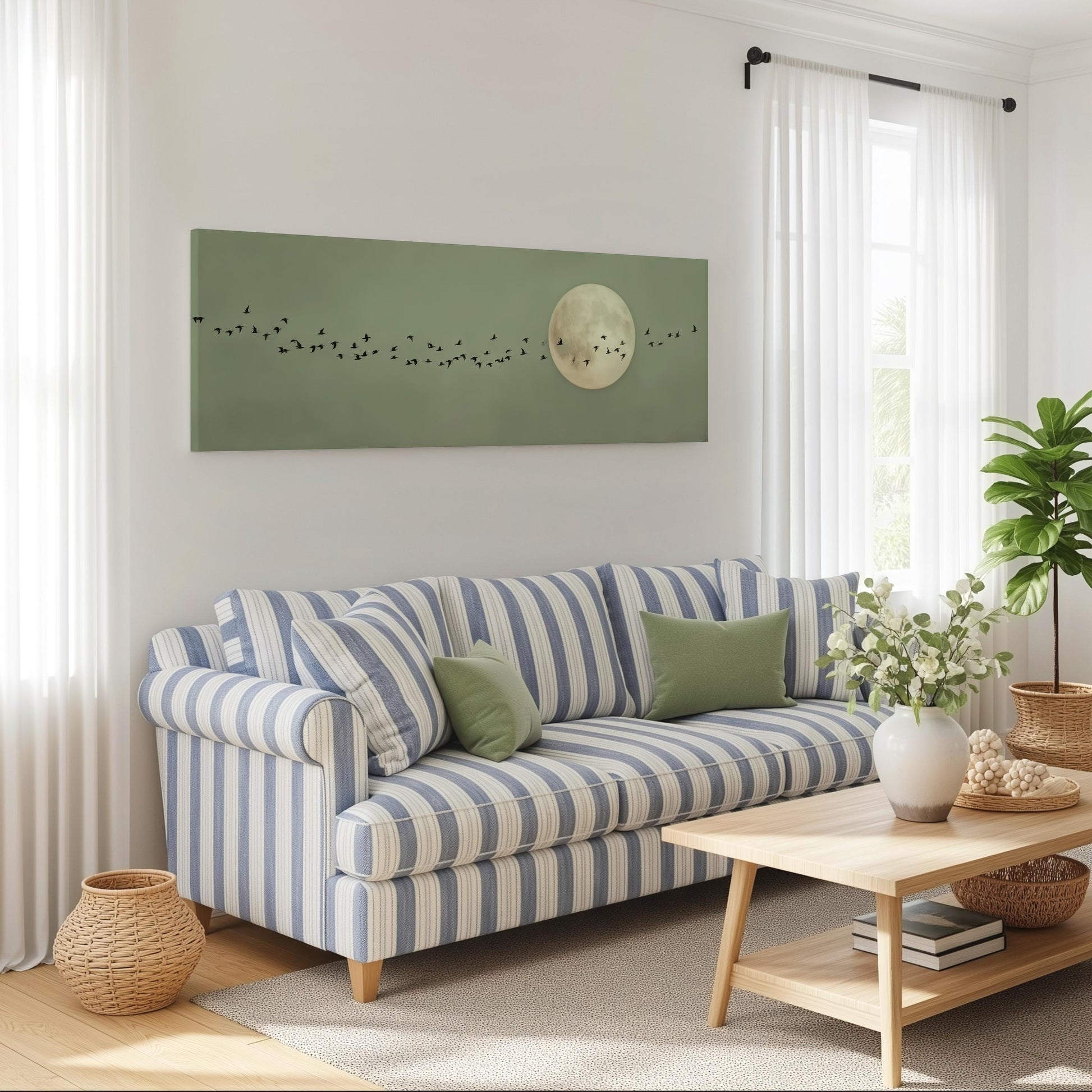 a cozy living room with a striped blue and white sofa, a wooden coffee table, and a large green wall art piece depicting a full moon with birds.