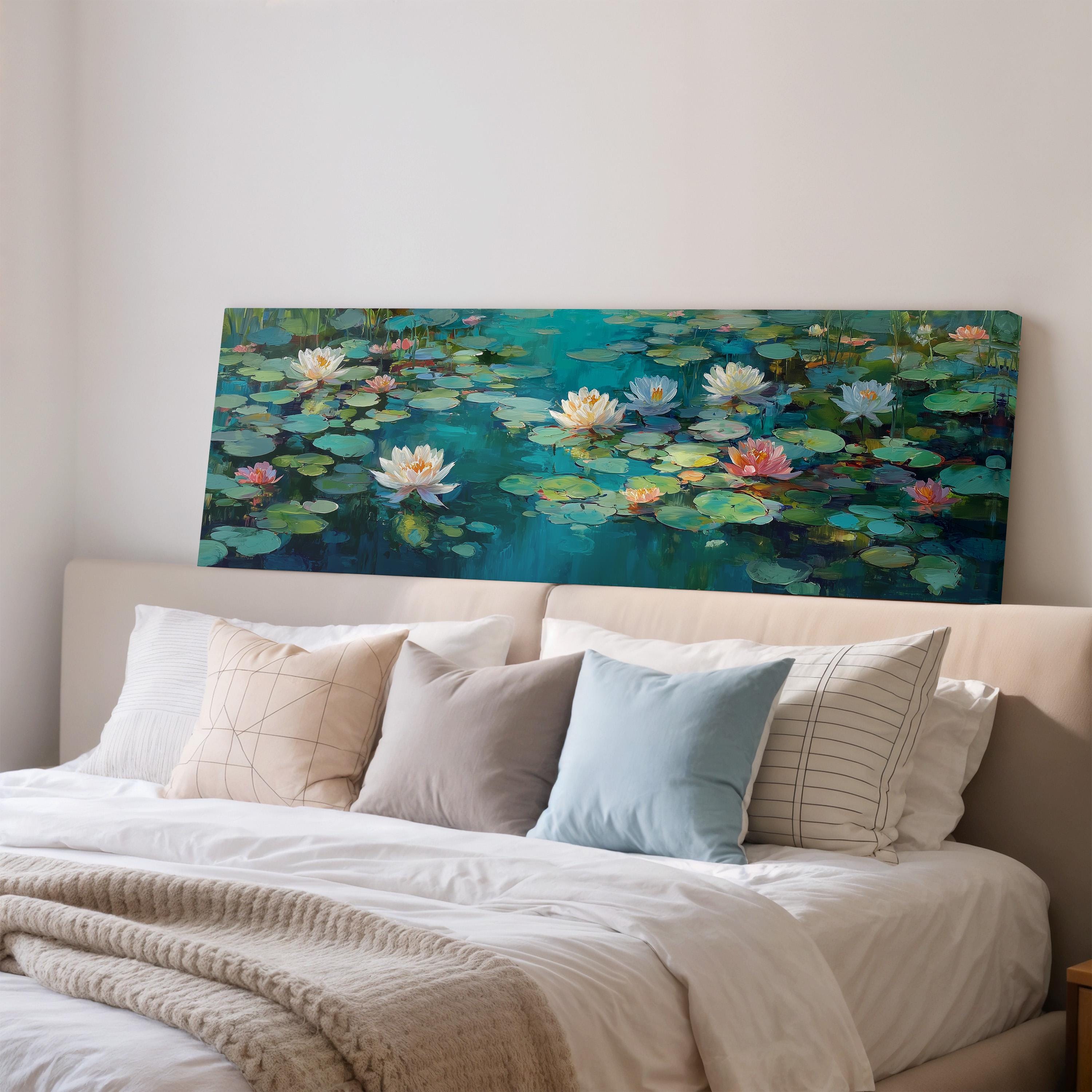 a large painting of lily pads on a wall above a bed with white pillows and a gray blanket.
