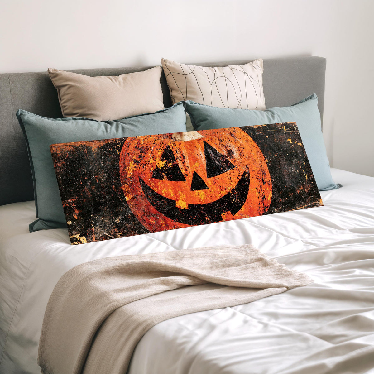 Rustic distressed jack-o'-lantern wide panoramic canvas print laid on a bed to show its size