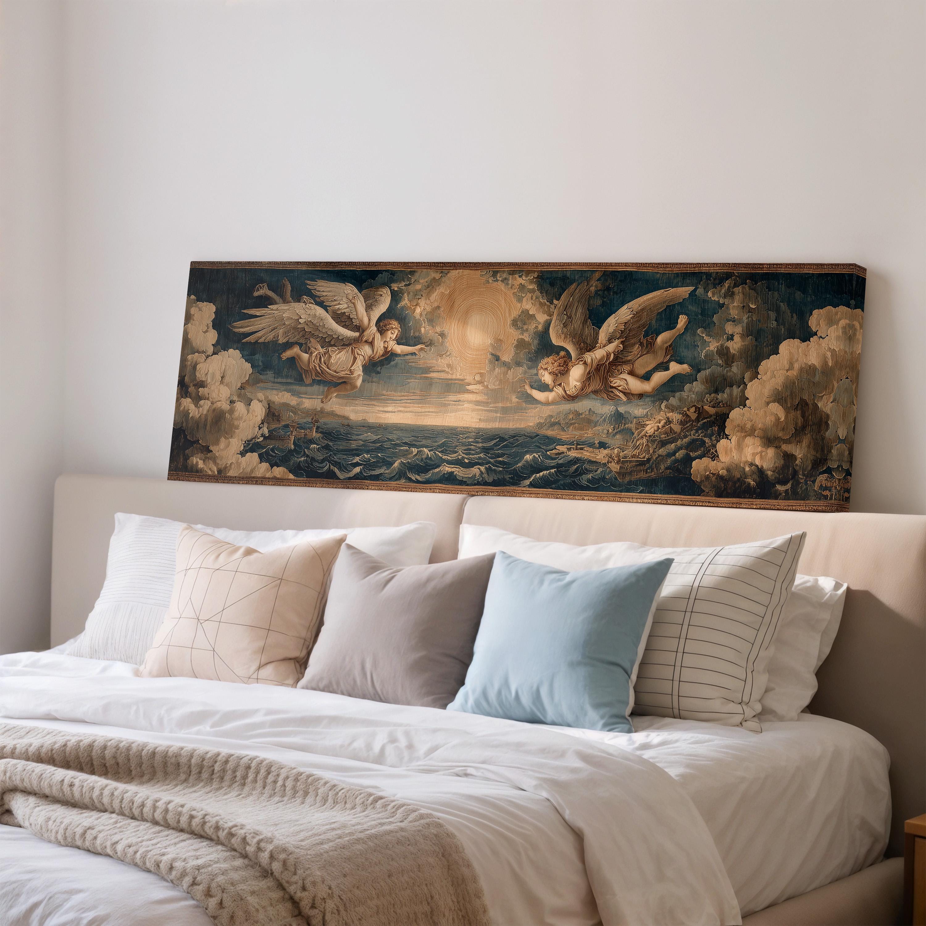 a large painting of angels on a bed with white pillows and a gray blanket.