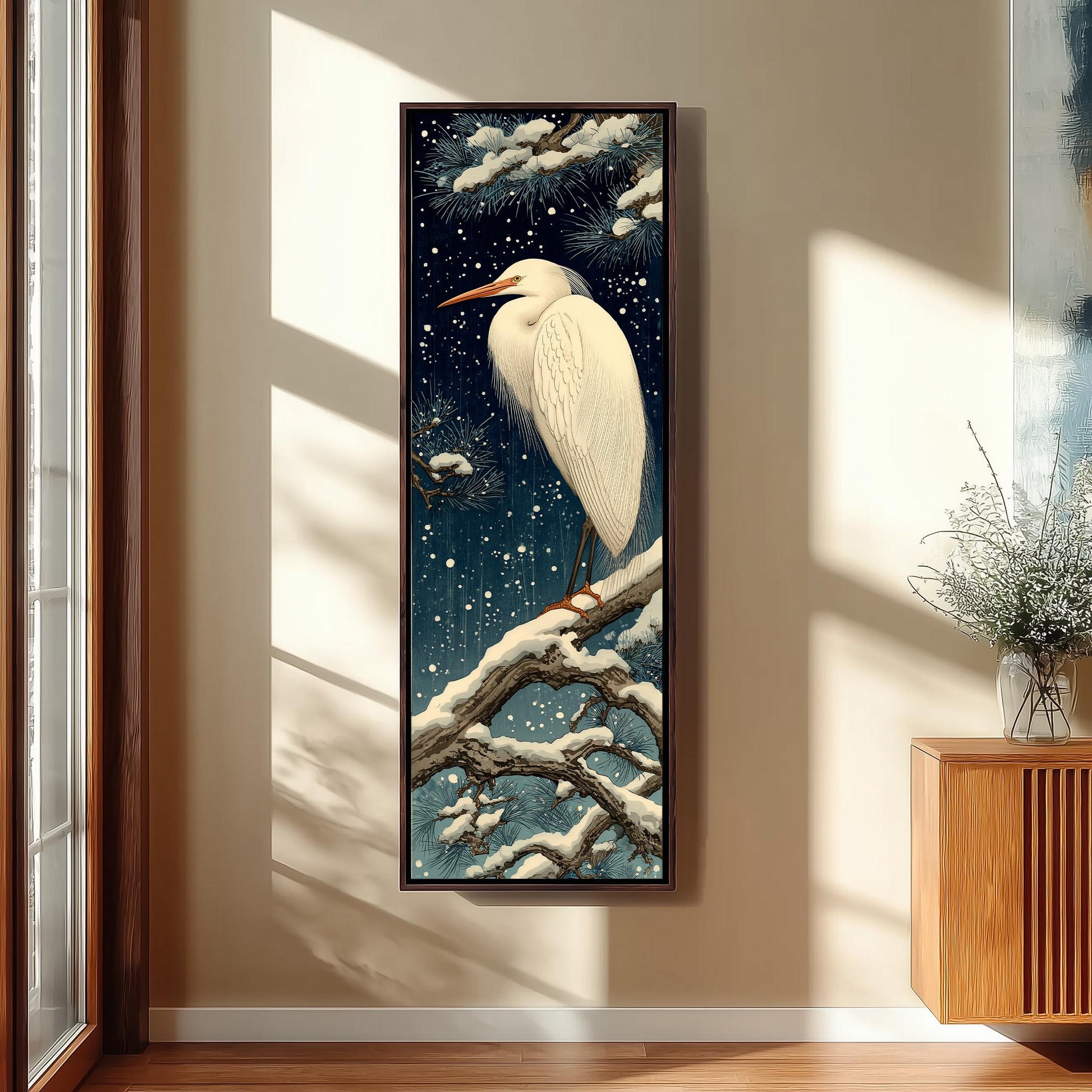 a large, framed painting of a white egret perched on a branch, with a snowy background and twinkling stars.