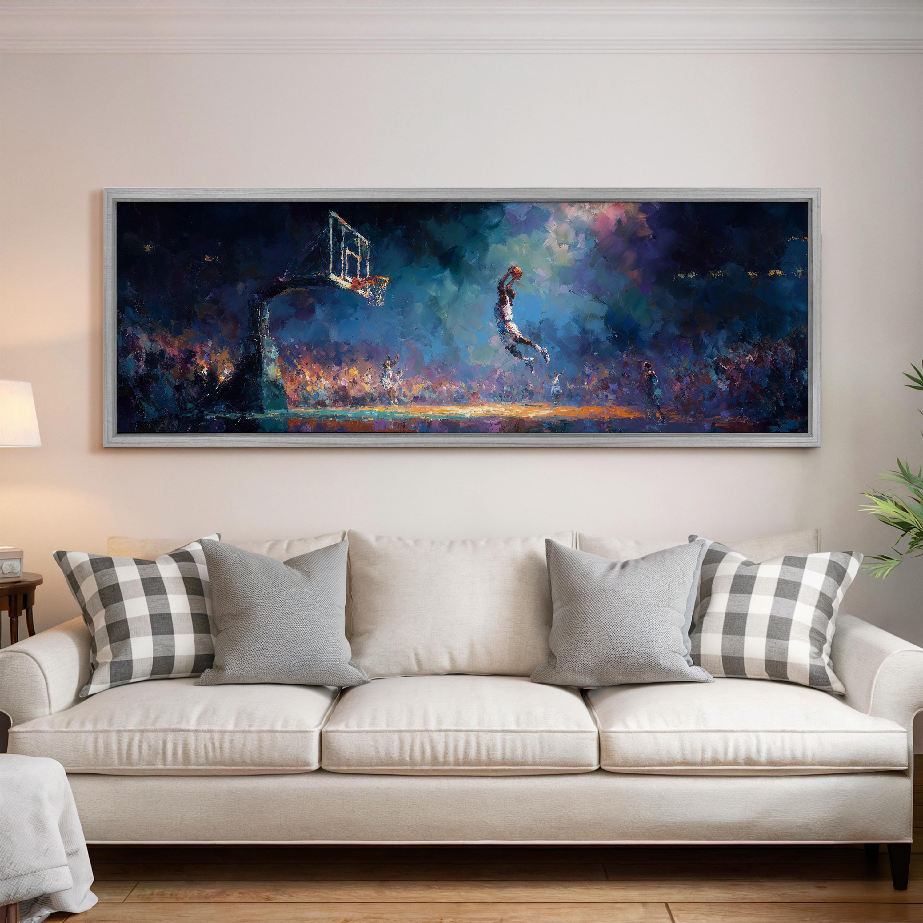 a large, colorful painting of a basketball game in progress, with a player jumping up to take a shot. The painting is displayed on a wall above a white couch, which is positioned in front of a lamp.