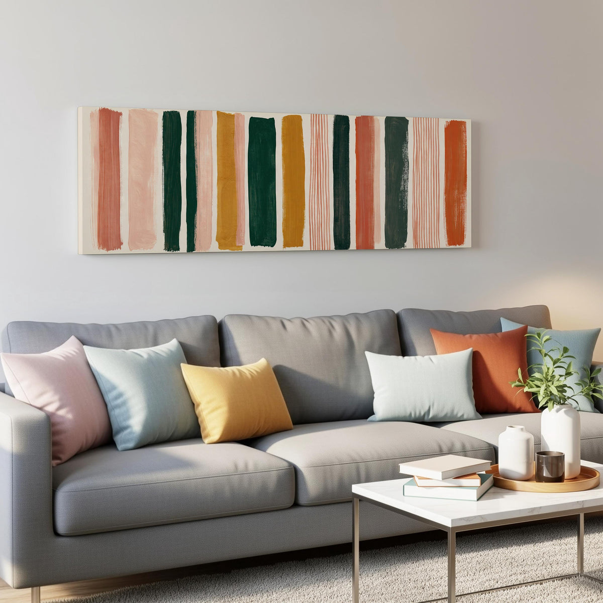 Mixed stripe blocks in terracotta, pink and green panoramic canvas print above a grey sofa in a living room