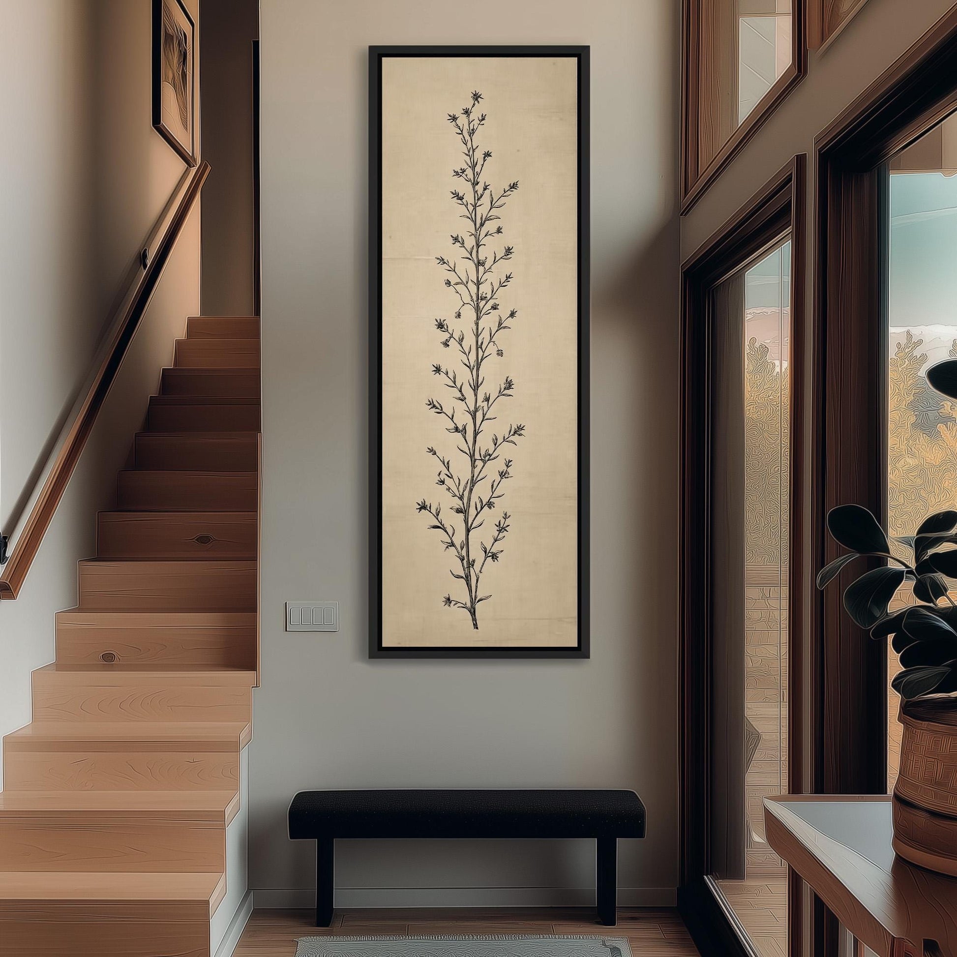 a hallway with a wooden staircase, a large framed artwork depicting a tree on the wall, and a black bench in the foreground.