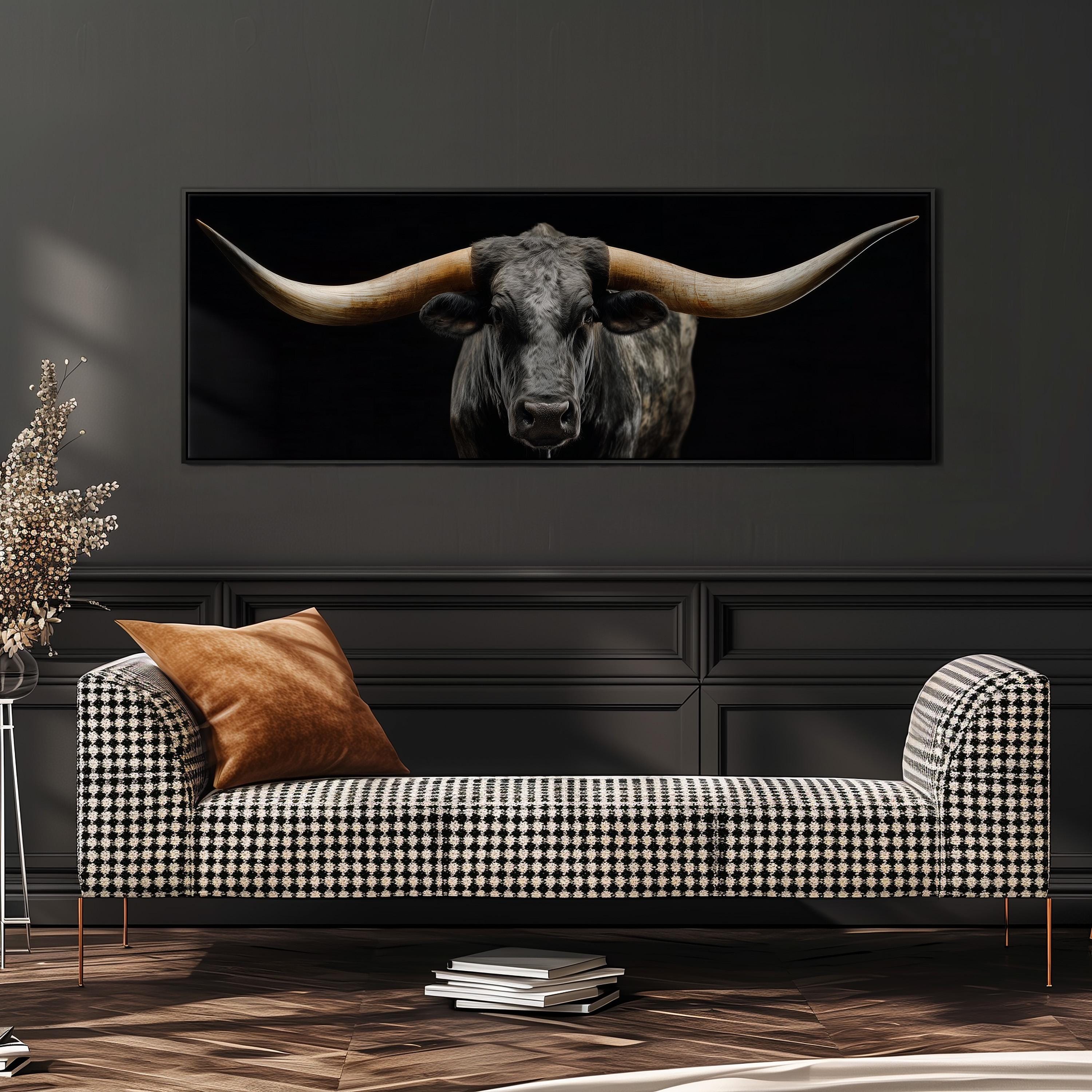 a large black bull with long horns, which is displayed on a wall above a black and white checkered sofa.