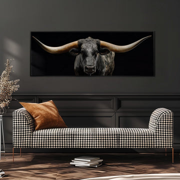 a large black bull with long horns, which is displayed on a wall above a black and white checkered sofa.