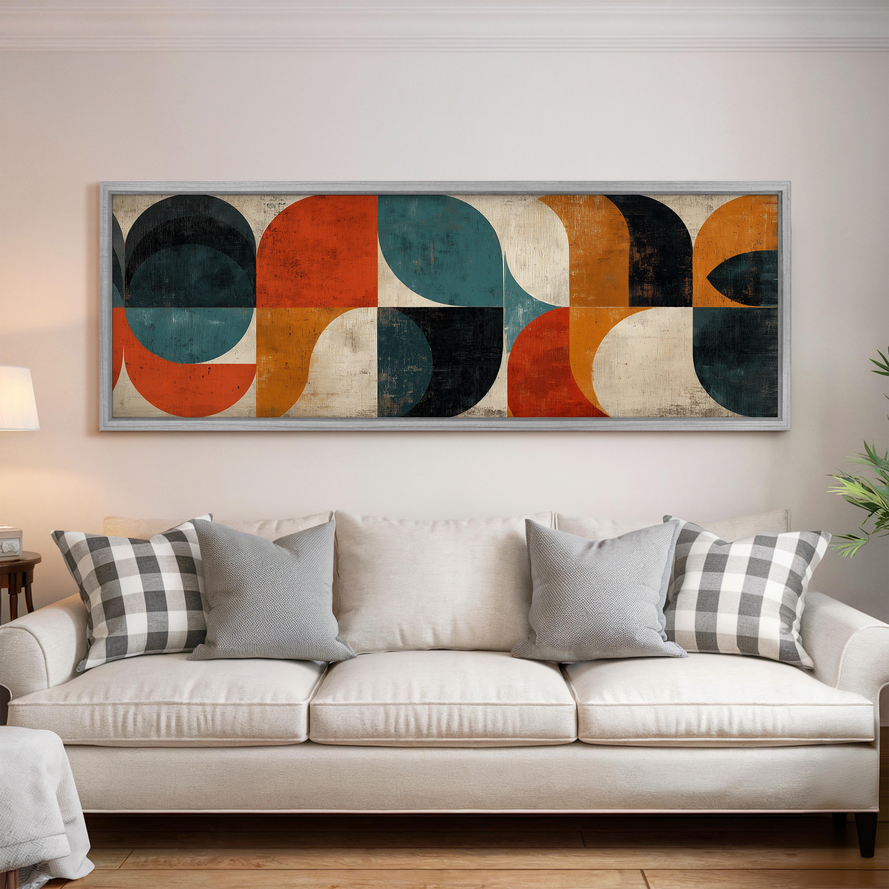 a large abstract painting hanging on a wall above a white couch with gray and black plaid throw pillows.